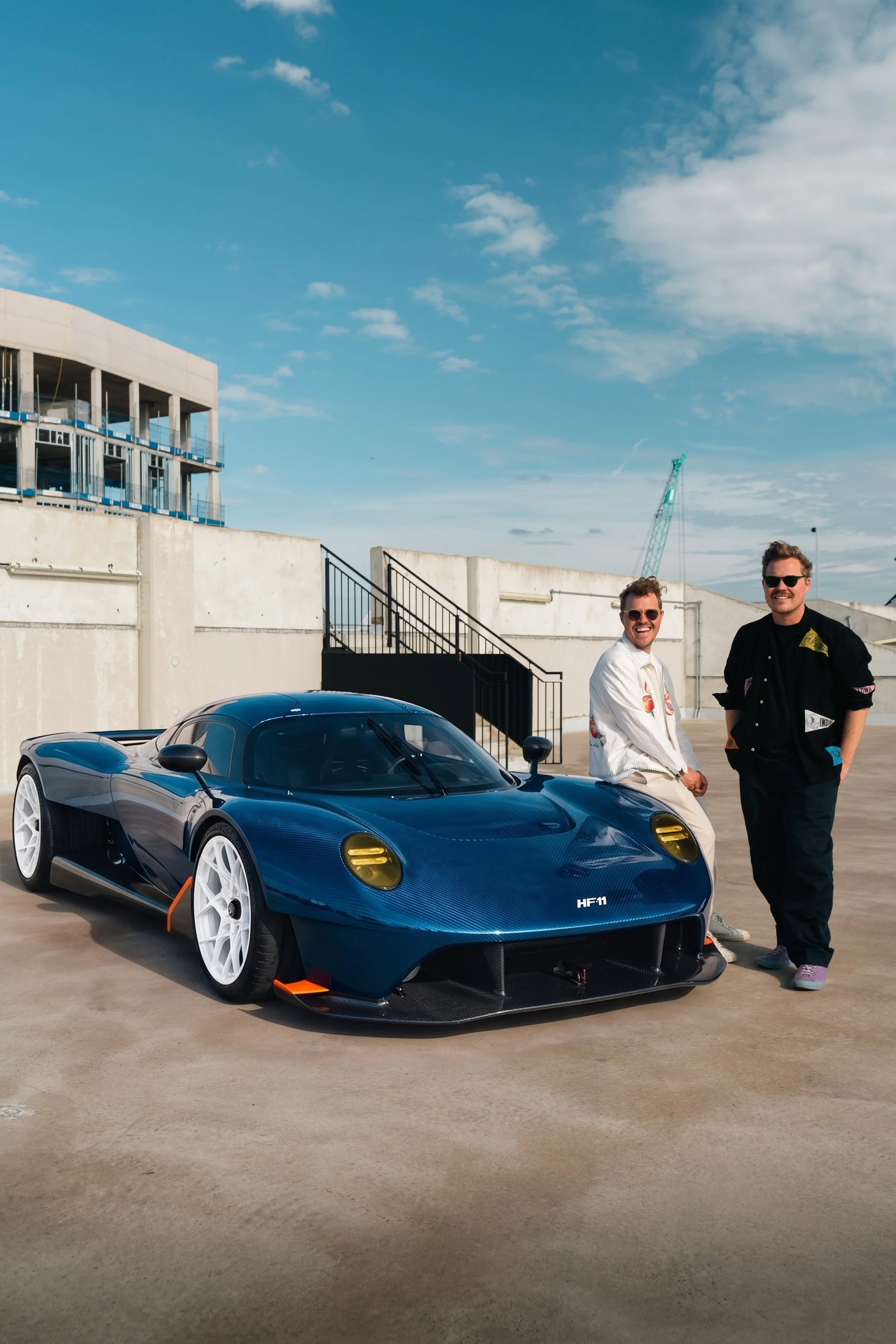 Nikita and Iliya Briday posing in front of an HF-11 with an industrial background