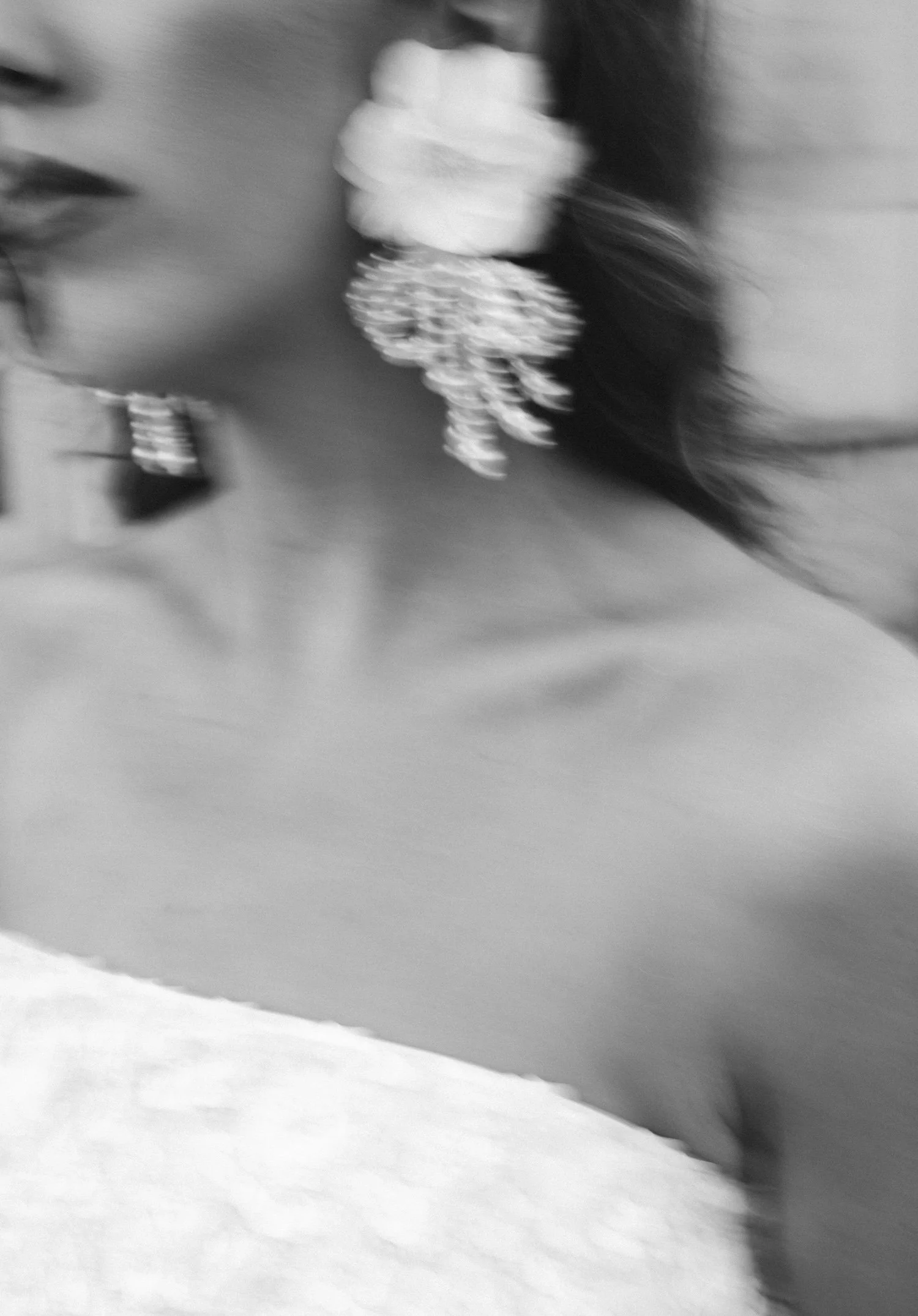 Close-up of a woman wearing large floral earrings, with her face partially visible in profile.