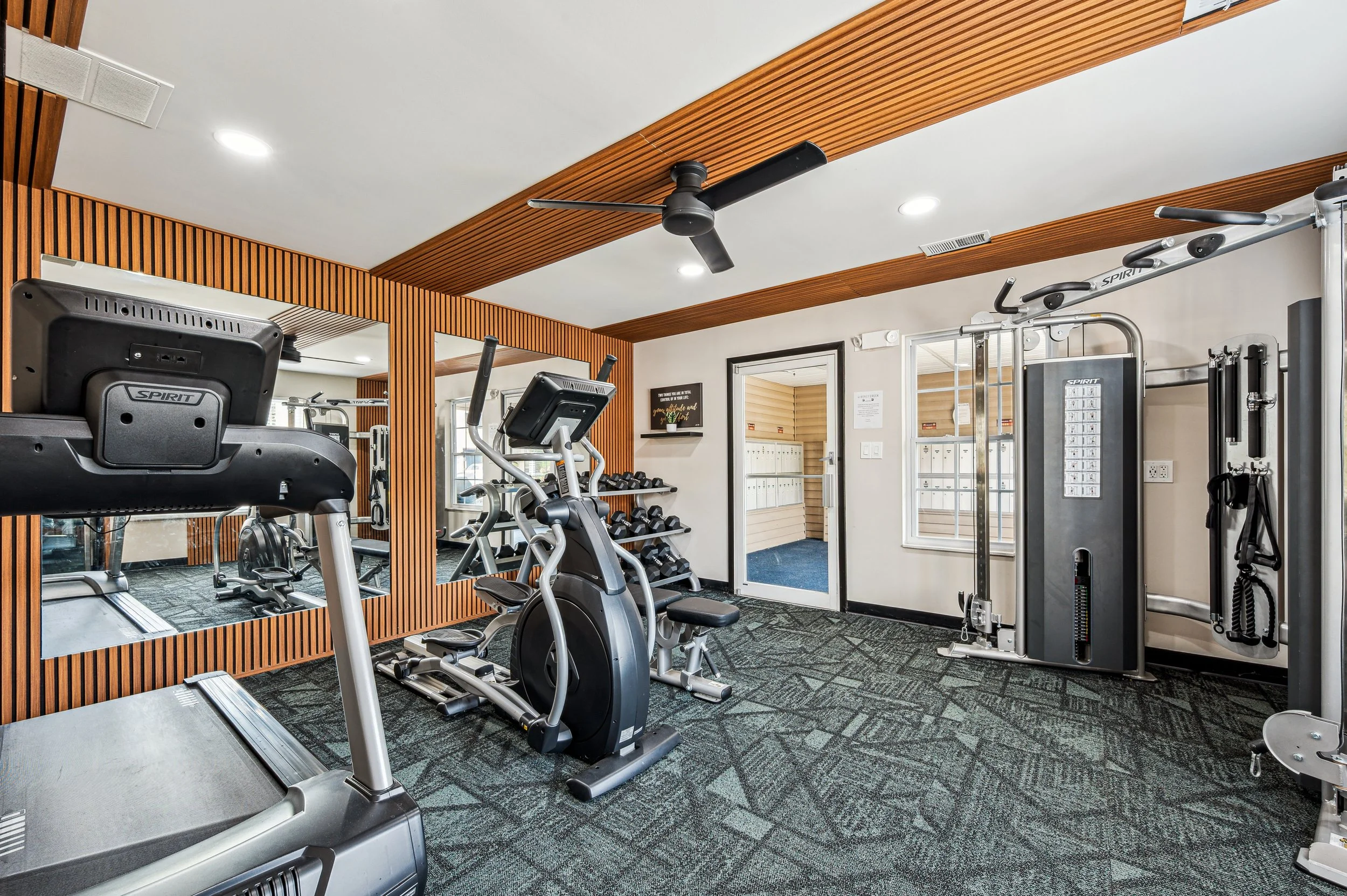 Image of honey creek's fitness center including free weights, a cable machine, a treadmill, and an elliptical.