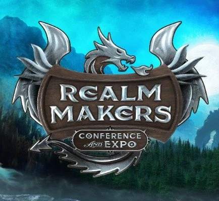Logo for the Realm Makers Conference and Expo featuring a dragon with wings behind a wooden shield, with mountains and forest in the background.