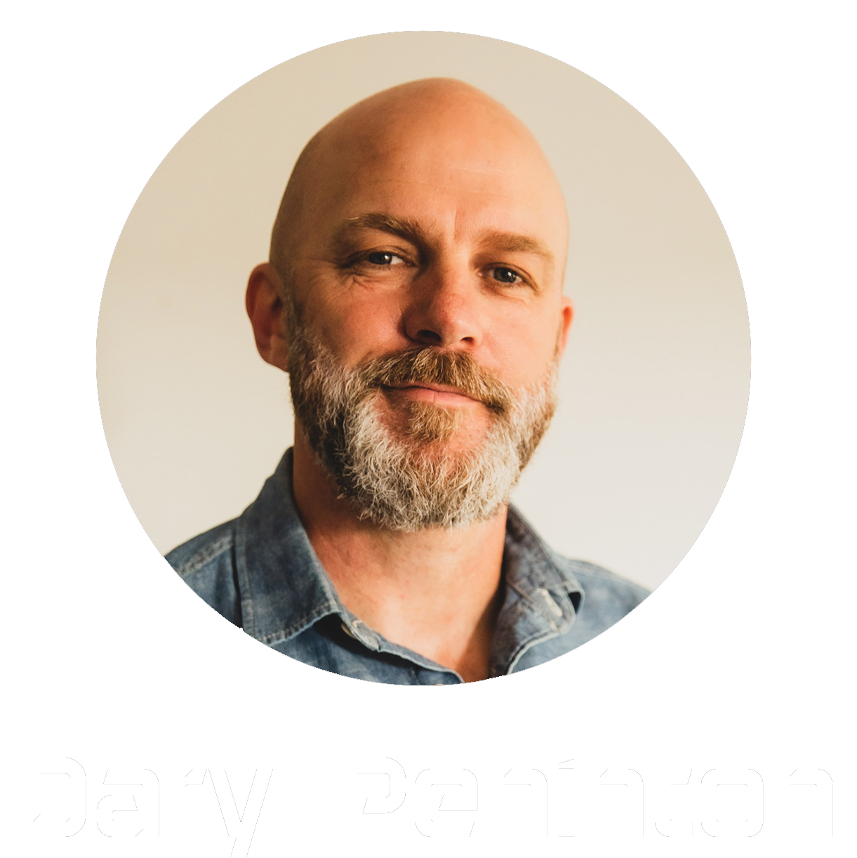 A middle-aged man with a beard and mustache, bald head, wearing a denim shirt, smiling softly against a plain light-colored background, with the name 'Daryl Peninton' written below.