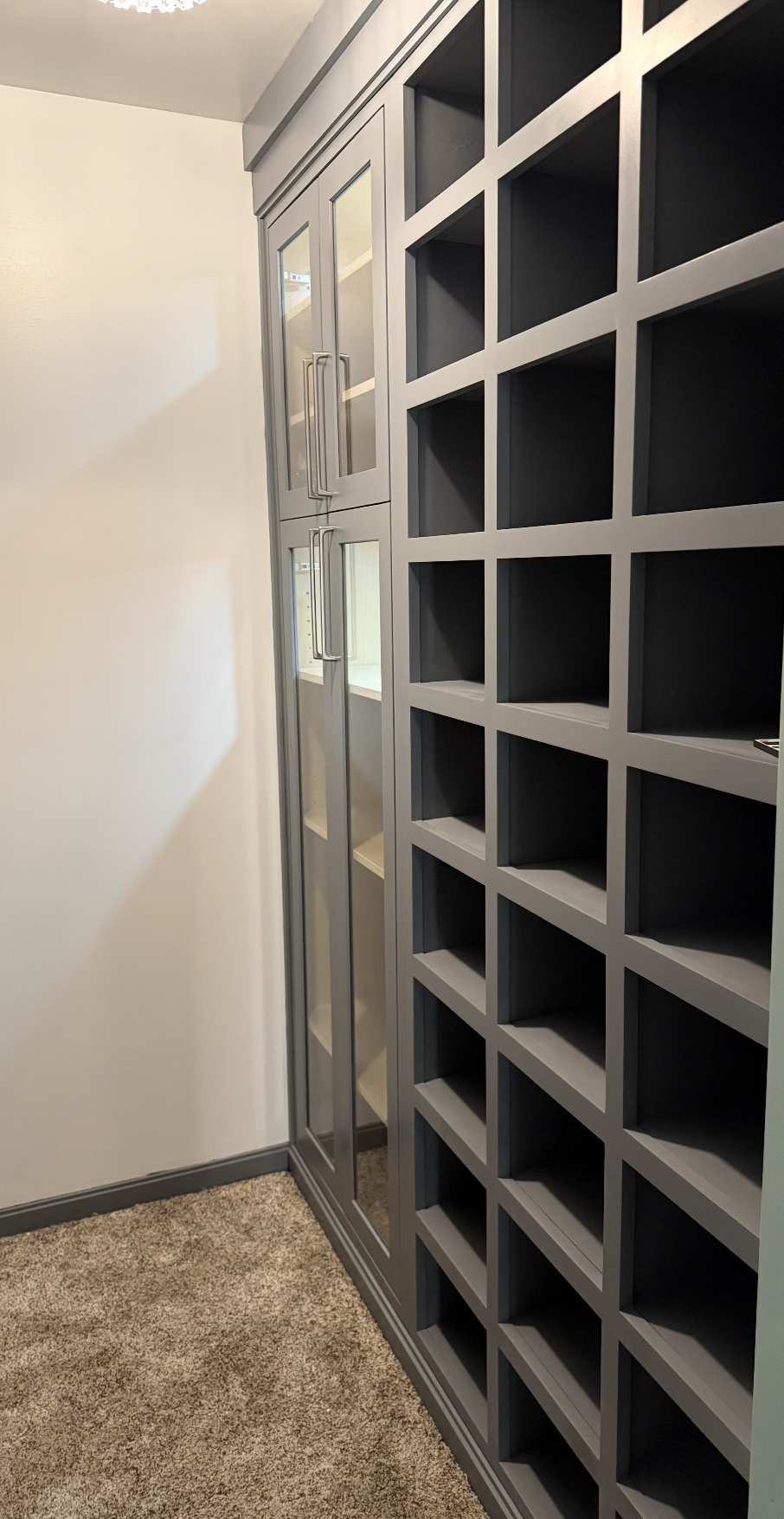 A walk-in closet with shoes organized in a drawer and clothes hanging above on hooks.