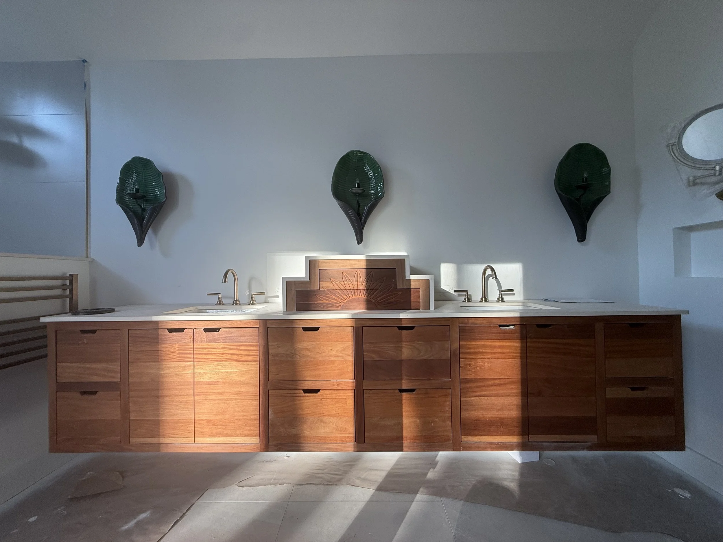 A kitchen with a wooden cabinet, two sinks, and three Darth Vader masks mounted on the wall.