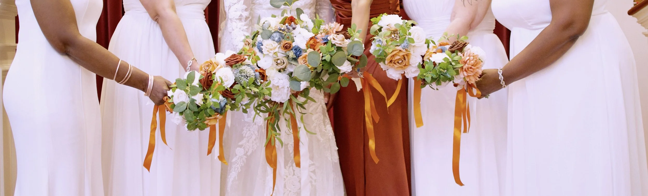 A group of women in wedding dresses holding floral bouquets during a wedding ceremony