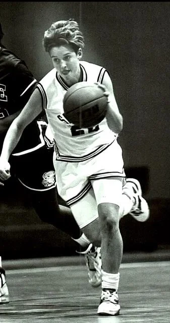 Silhouette of a woman with illuminated hair, facing left, against a dark background.