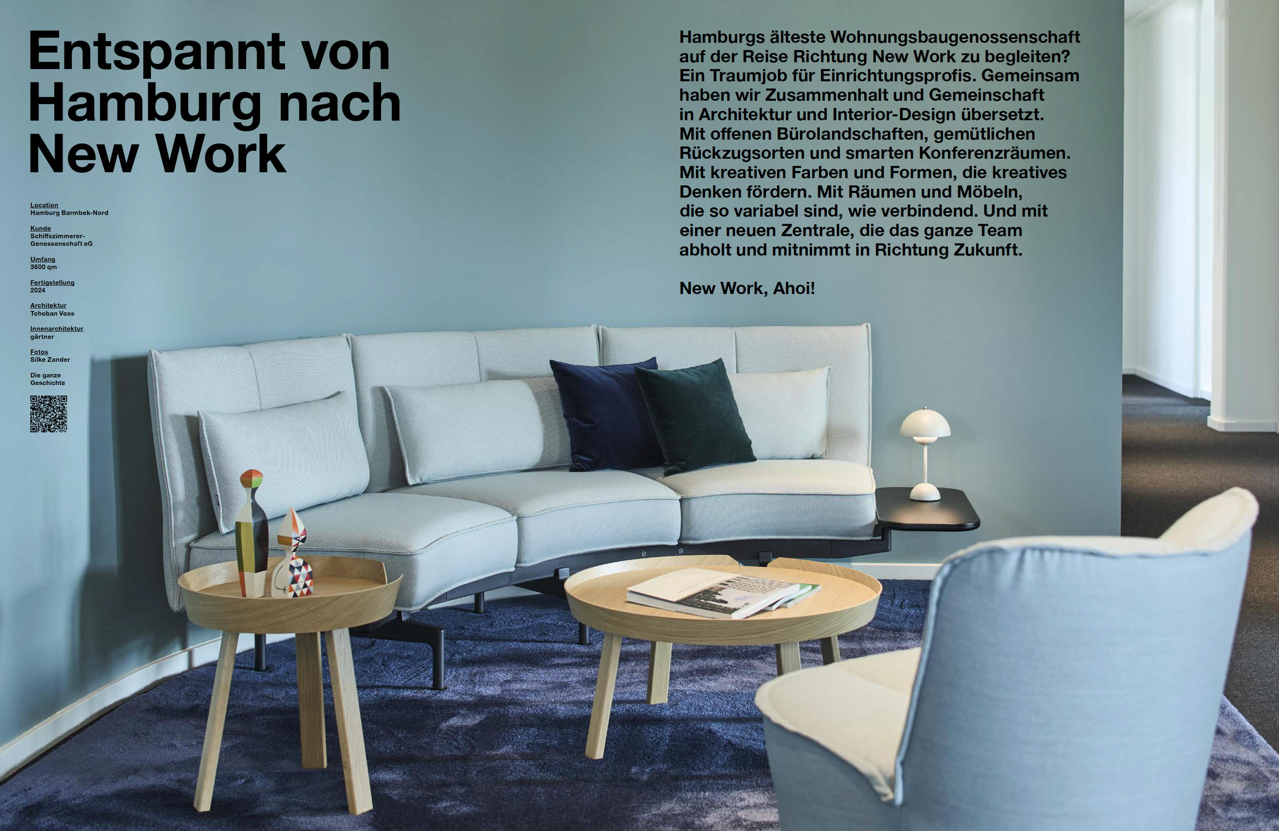 Ein modernes Wohnzimmer mit einem hellblauen Wand, einem weißen Sofa mit dunklen Kissen, einem runden Holztisch mit aufgelegten Zeitschriften, einem kleinen Beistelltisch mit dekorativen Figuren sowie einem weißen Tischlampen und einem türkisen Teppi