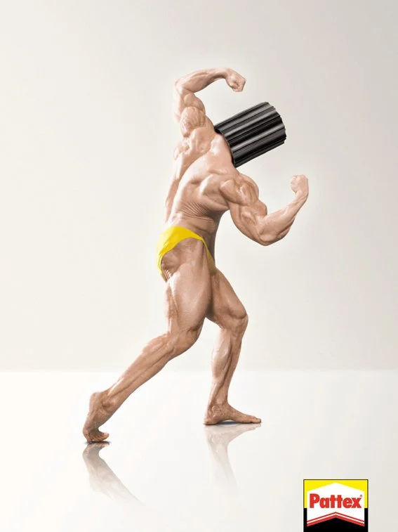Ein muskulöser Mann mit einem schwarzen Zylinderkopf, der wie ein Dosenöffner aussieht, in einer Pose, die wie ein Bodybuilder-Posing wirkt, trägt gelbe Unterwäsche, vor hellem Hintergrund, mit Pattex-Logo im unteren rechten Eck.