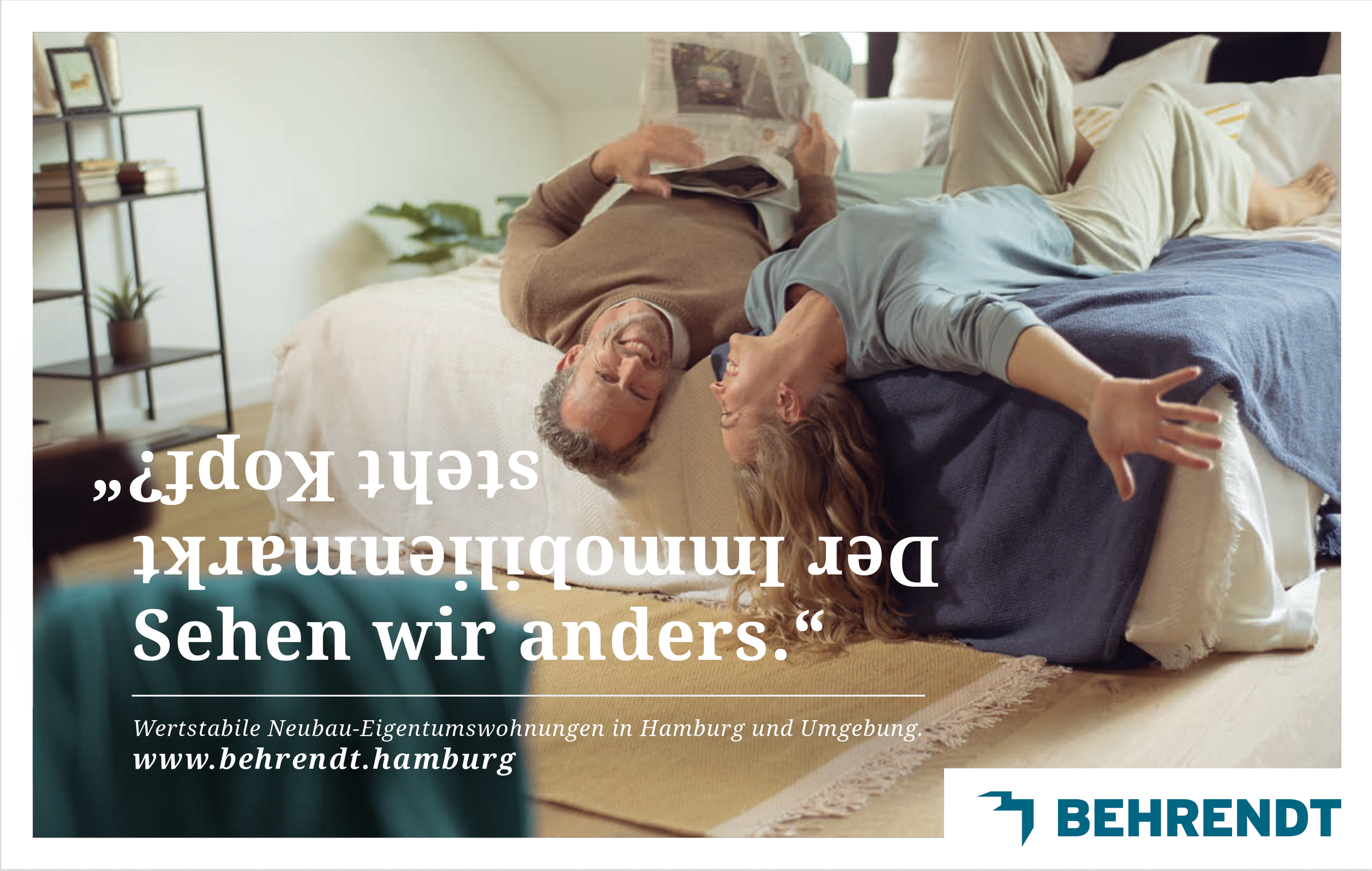 Ein älterer Mann und eine jüngere Frau liegen lachend auf einem Bett, die Frau streckt einen Arm aus, während der Mann Zeitung liest. Im Hintergrund ist ein Bücherregal und einige Pflanzen zu sehen.