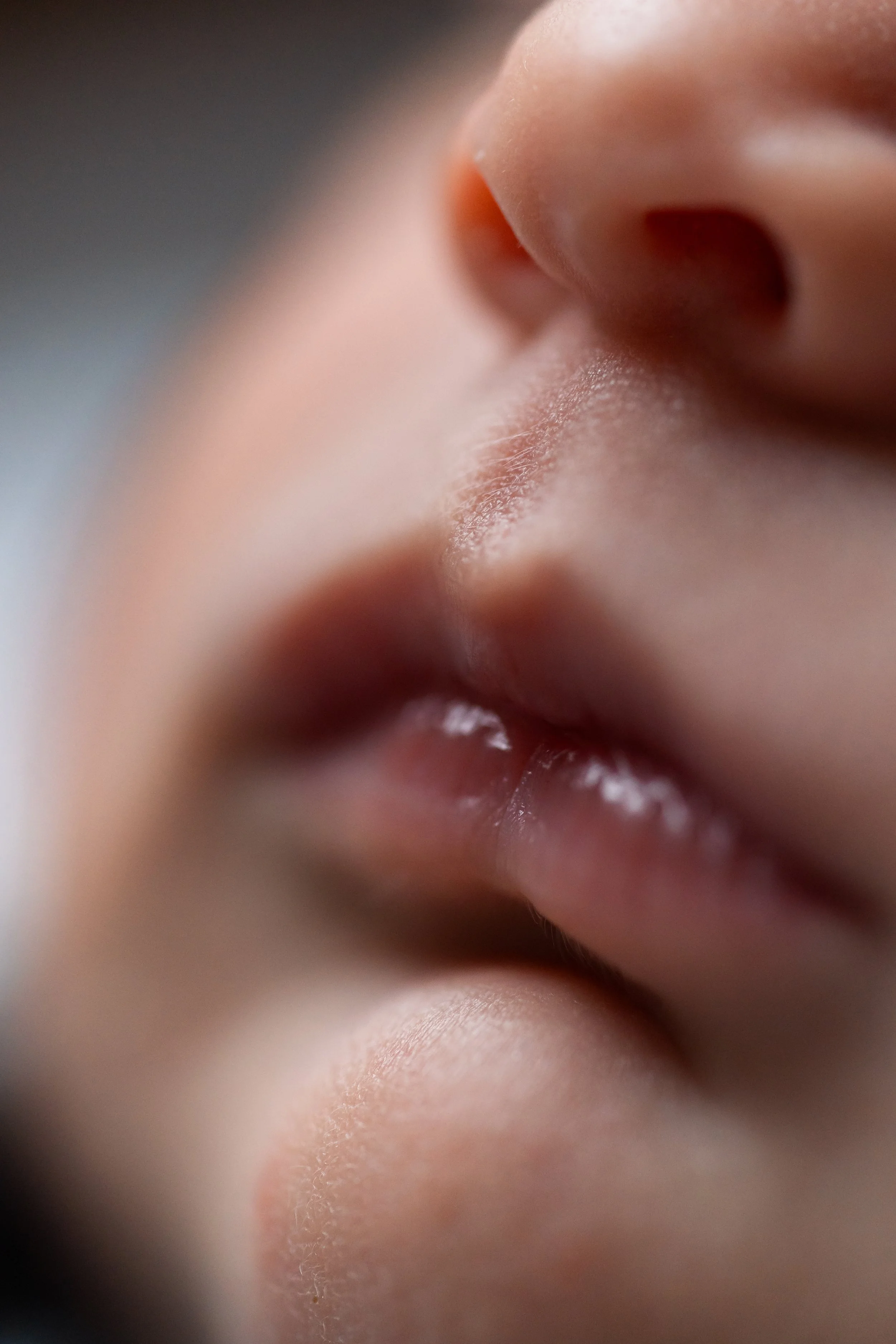 Close-up of a newborn baby's nose and lips, highlighting soft skin and tiny details, captured during an in-home newborn photo session in the Champel area of Geneva