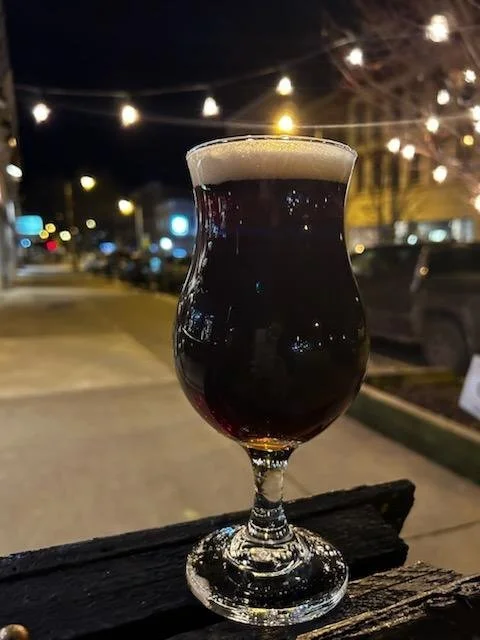 A dark beer is pictured outside at night at Here & Now Brewing Company in Honesdale, PA.