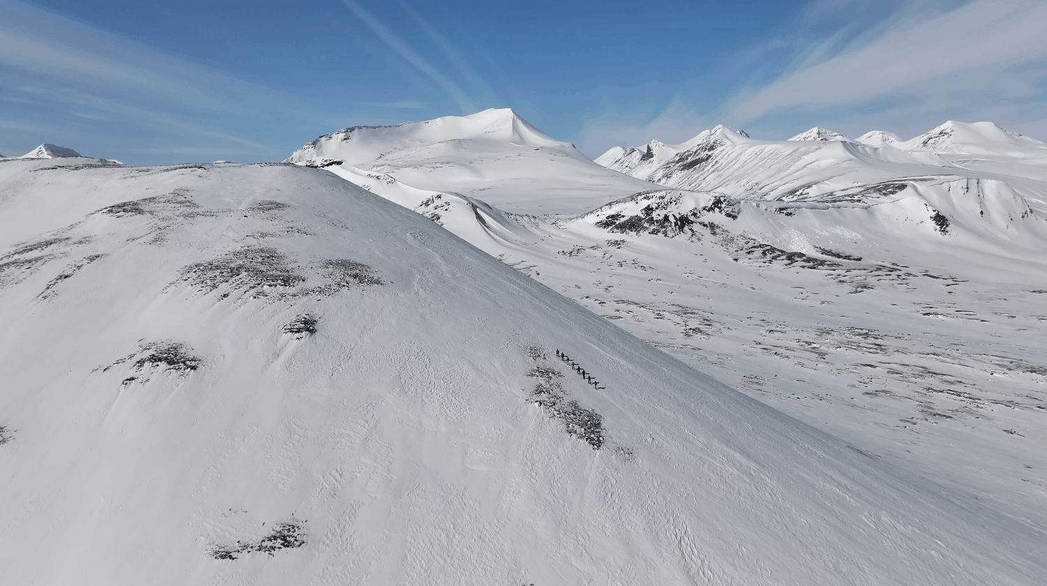 Snötäckta berg och bergstoppar under en klar blå himmel