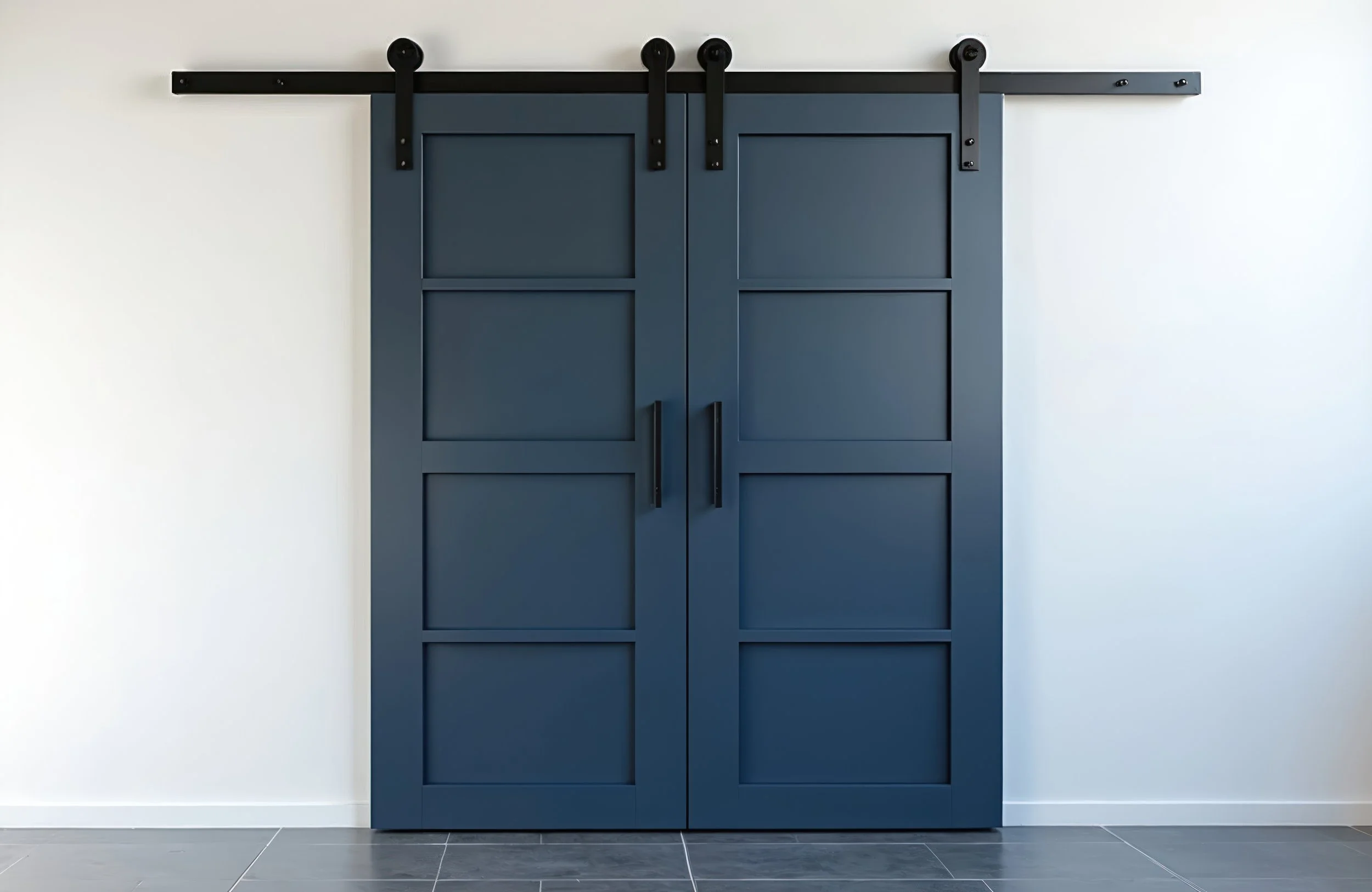Blue sliding barn doors with black hardware on white wall, gray tiled floor.