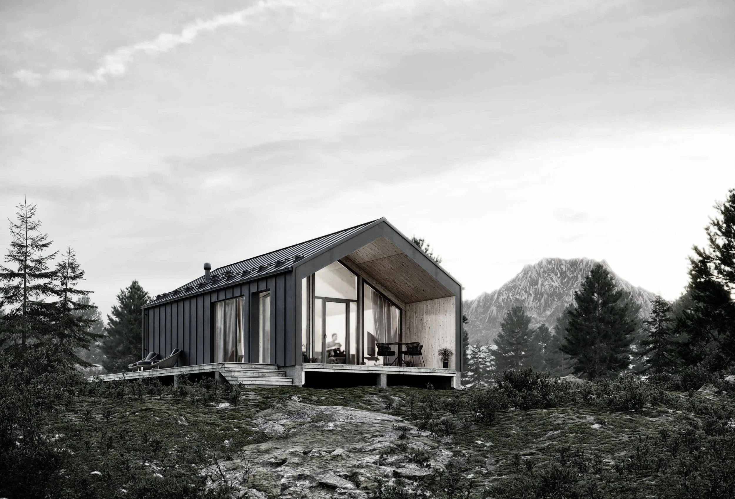 Modern house with large glass windows and a porch, surrounded by trees and mountains