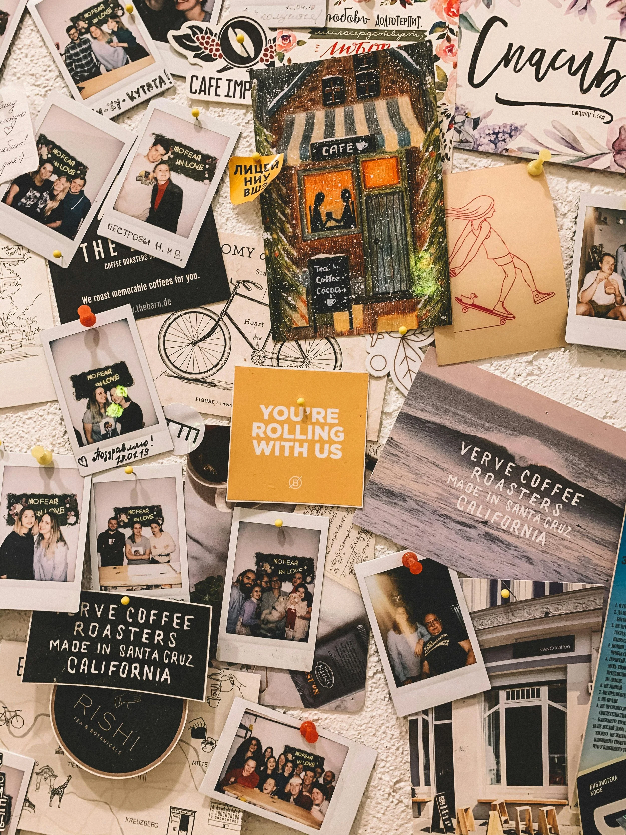 A collage of photographs, postcards, and drawings pinned on a wall as mood board inspiration.