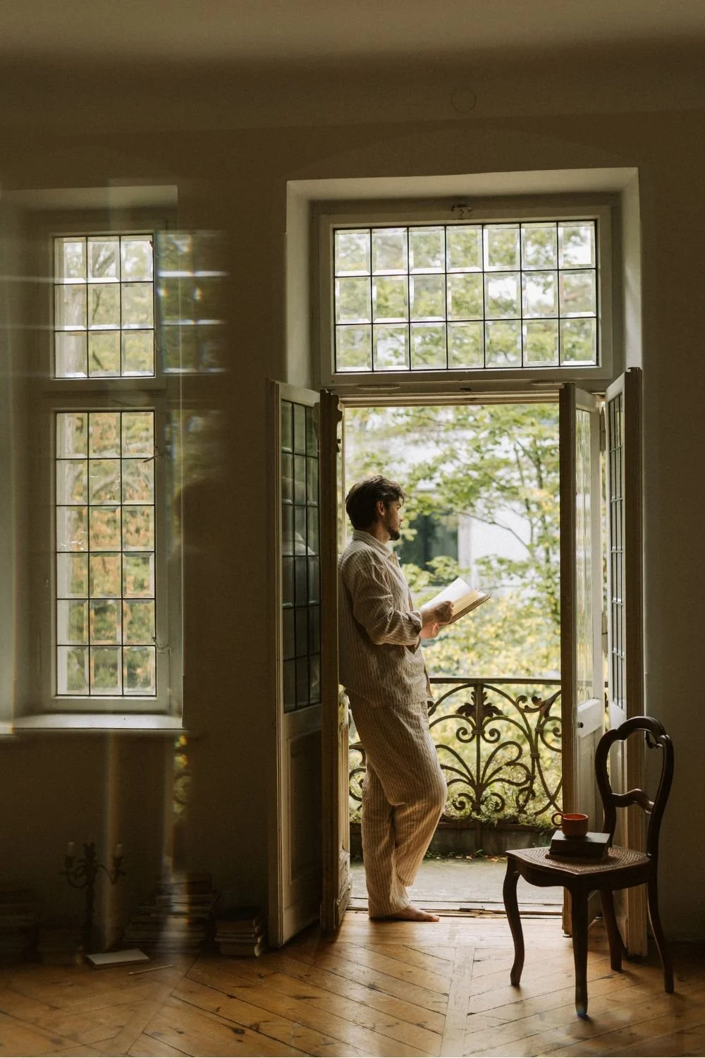 Small business owner standing next to a french door with a notebook.