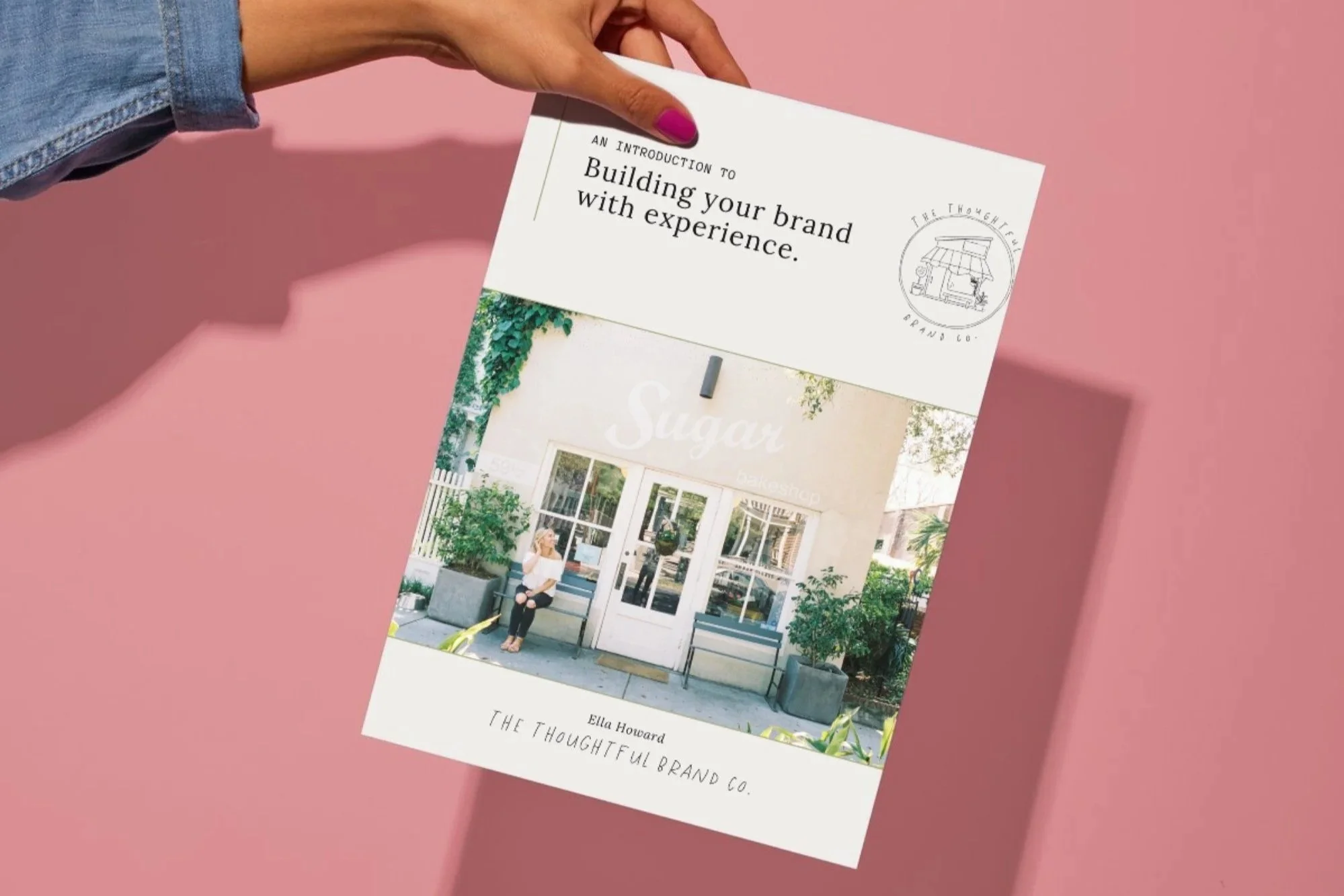 A person holding a printed copy of the guide "Building your brand with experience."