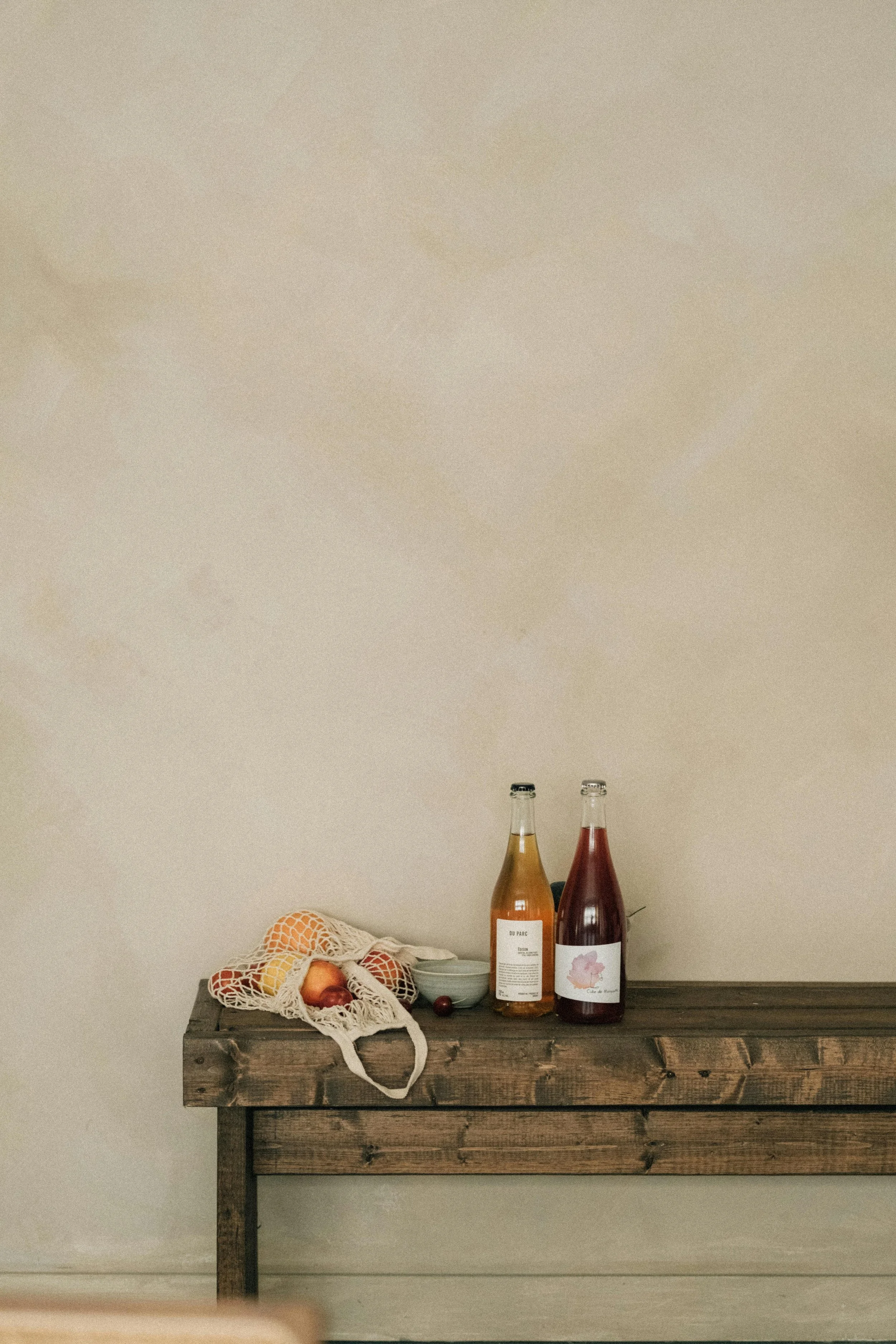 Small business — small batch natural wine paired with farmer's market fruit and a handmade ceramic bowl.
