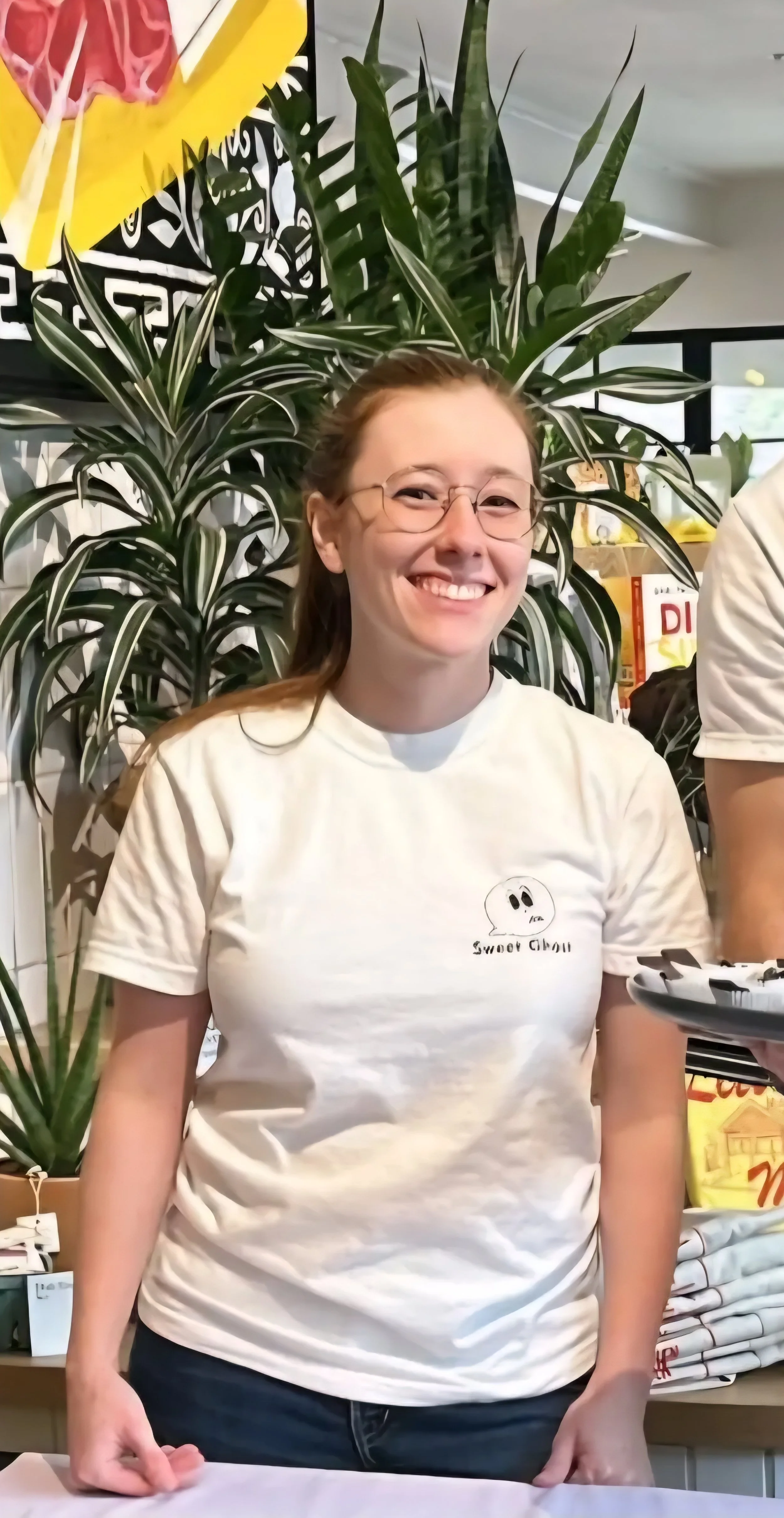 A picture of a young woman in a tshirt with glasses smiling