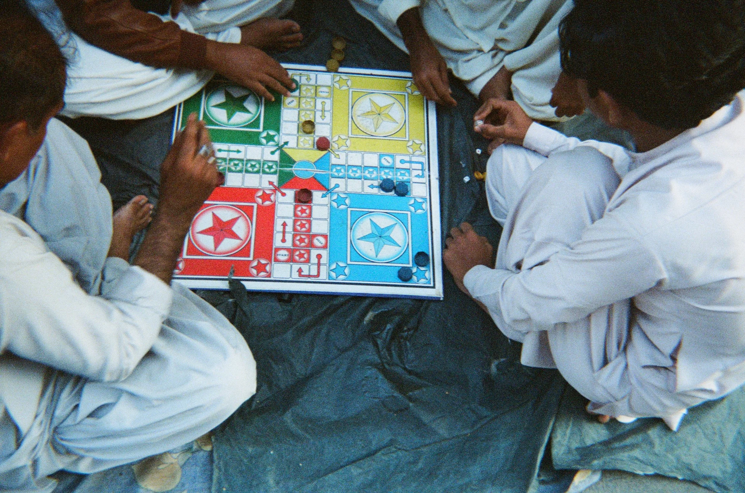 Hands playing Ludo, photographed by the STUDIO PURANI founder