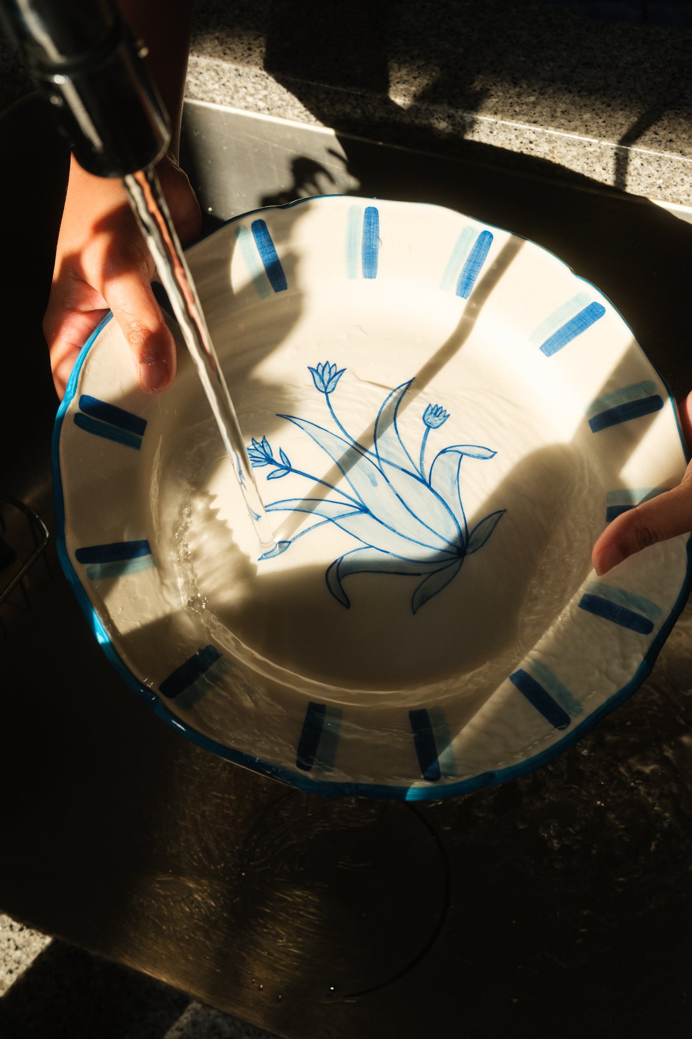 STUDIO PURANI Tulip dinner plate being hand washed in the sink