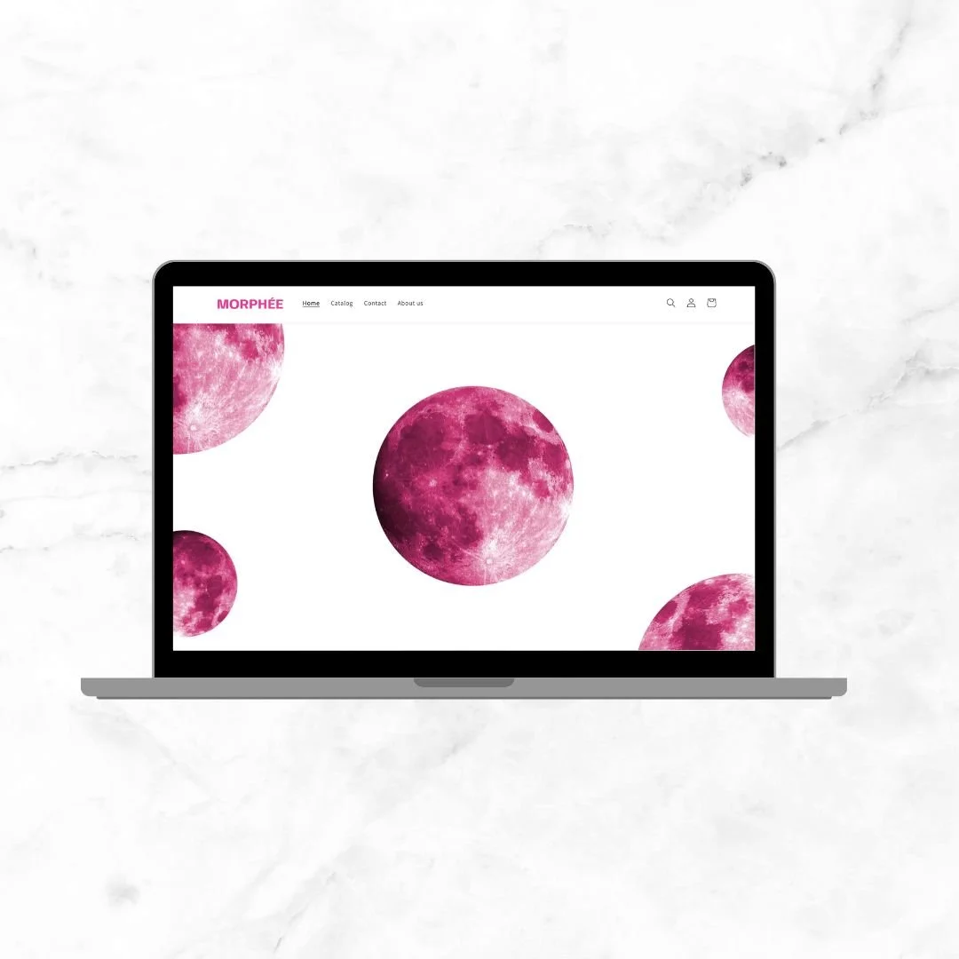 Laptop displaying a website with a white background and multiple pink moons.