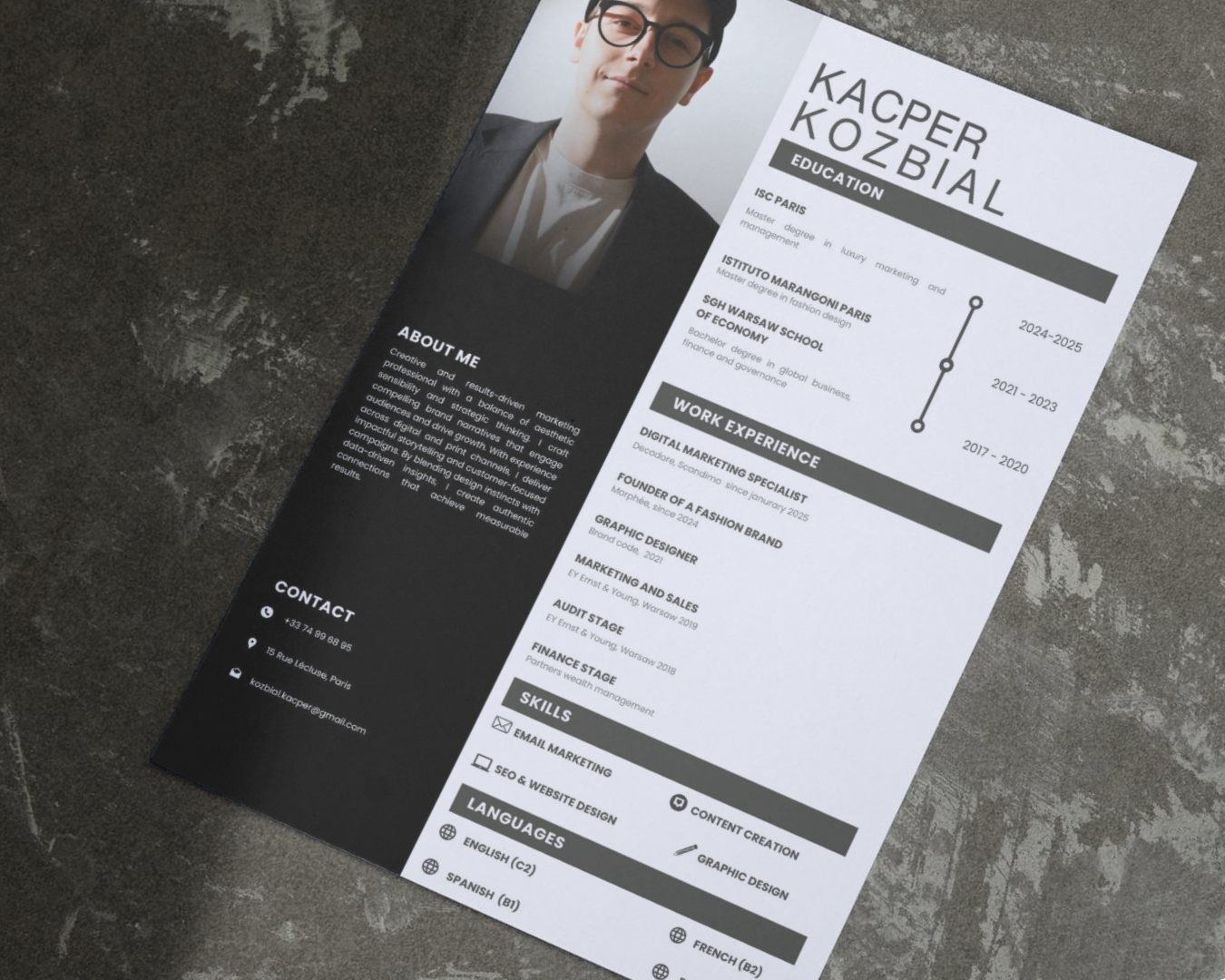 A printed professional resume laying on table, featuring  work experience of a  performance marketer