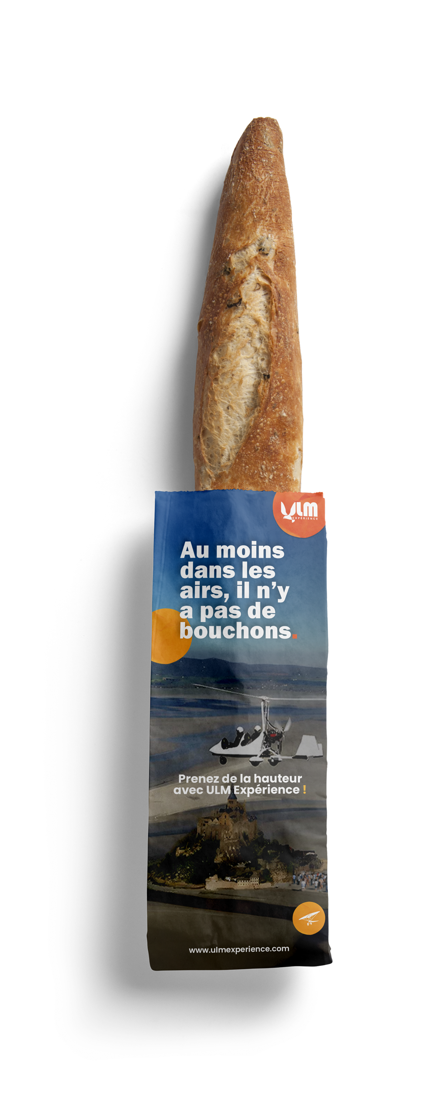 Une baguette de pain dans un emballage promotionnel d'ULM, avec texte encouragent la pratique de l'ULM et une photo d'un paysage avec un château et un avion léger.