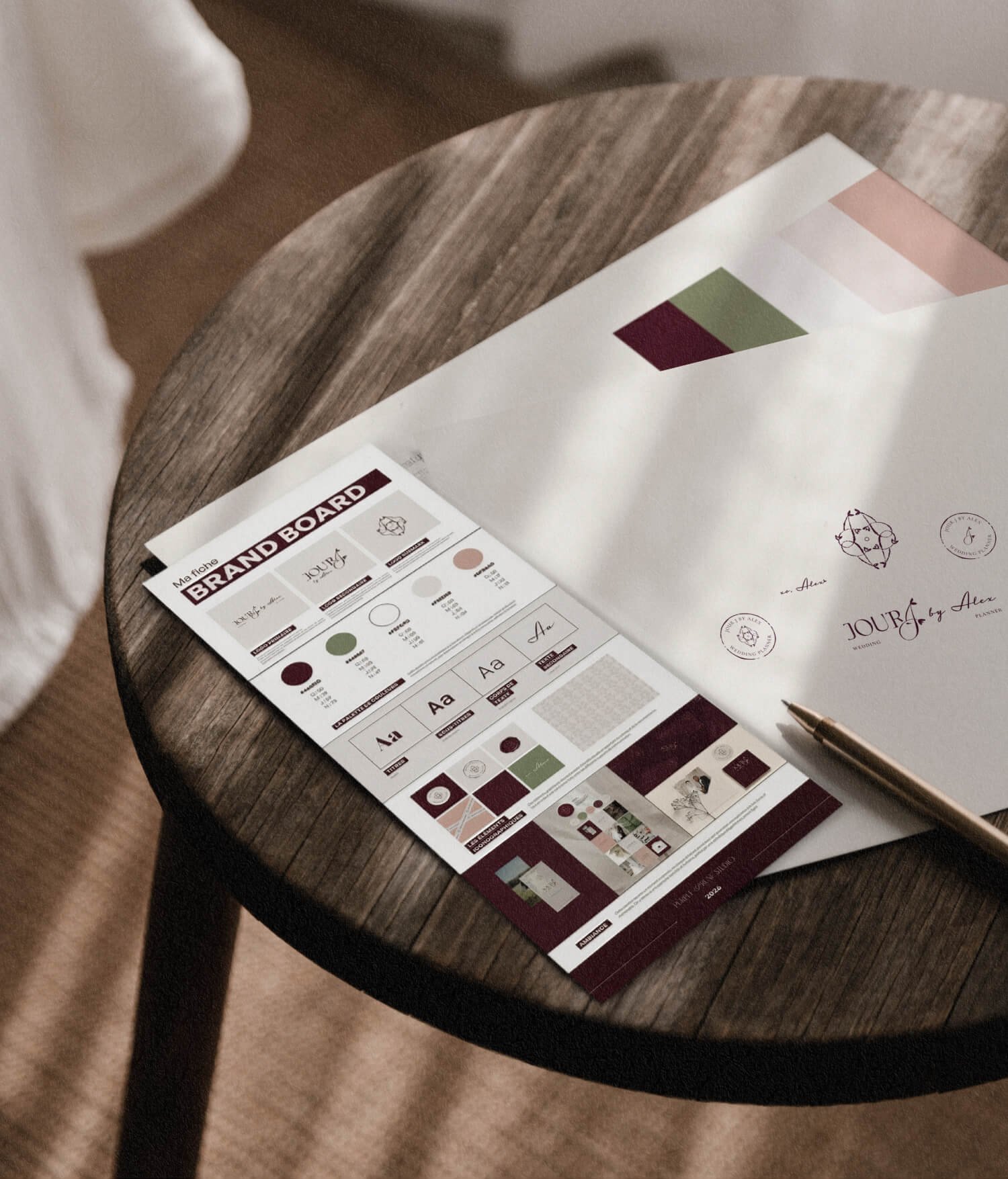 Documents de planification et de branding sur une table en bois, avec un stylo à côté.