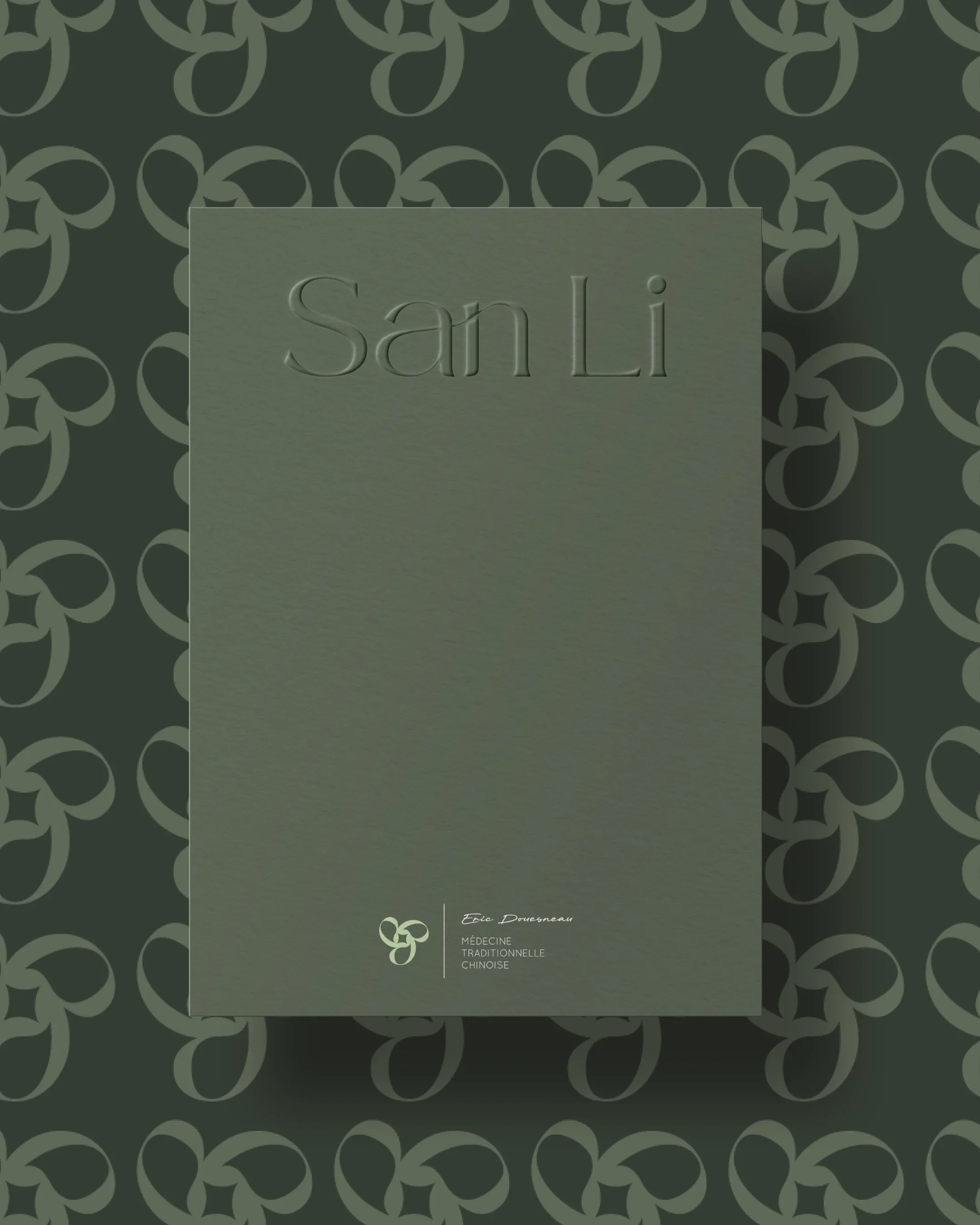 Couverture de livre verte avec le titre 'San Li' en relief, fond à motif de symboles décoratifs foncés, et nom de l'auteur Éric Drouenneau en bas.