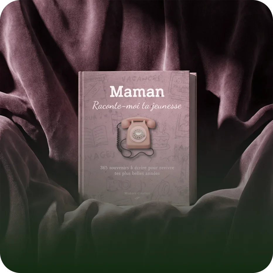 Livre rose avec une vieille radio de téléphone en décoration, entouré de tissu mauve et sombre.