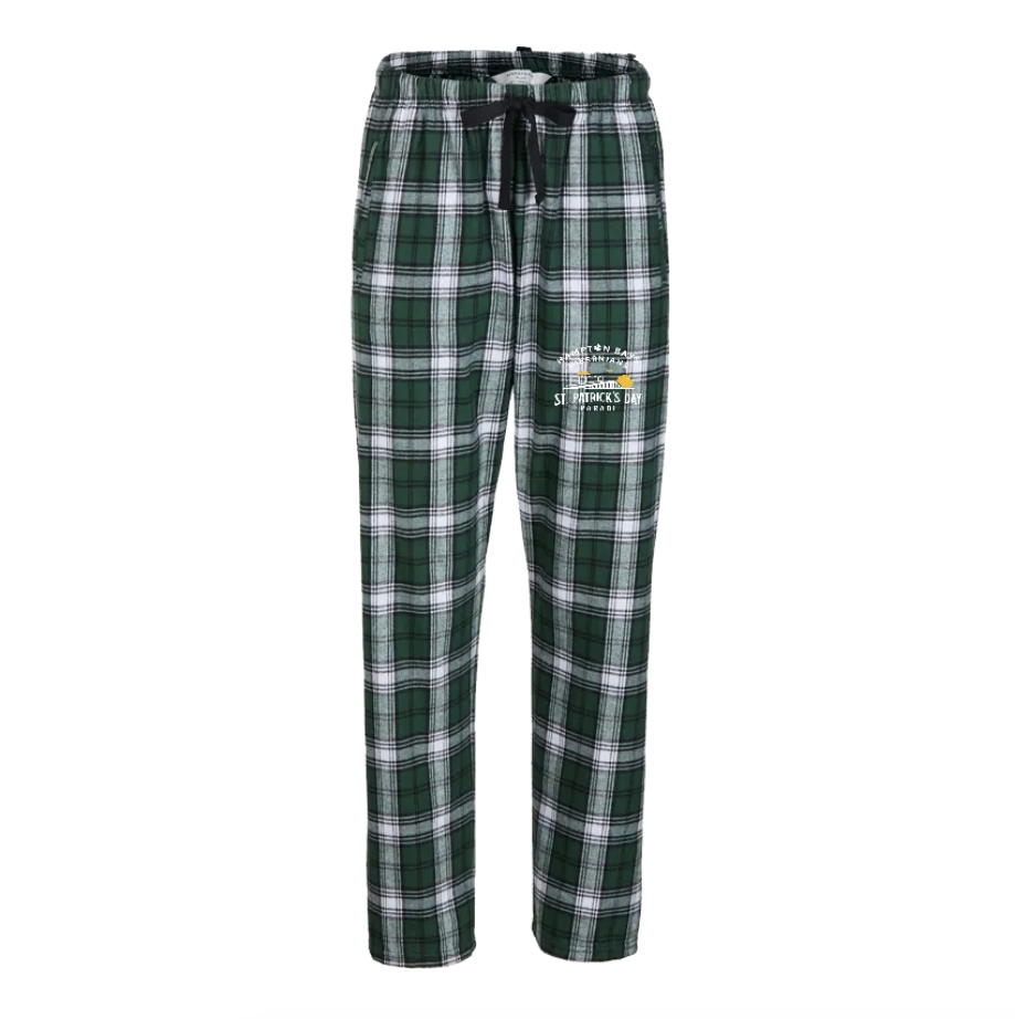 Green and black plaid pajama pants with a St. Patrick's Day graphic on one leg.