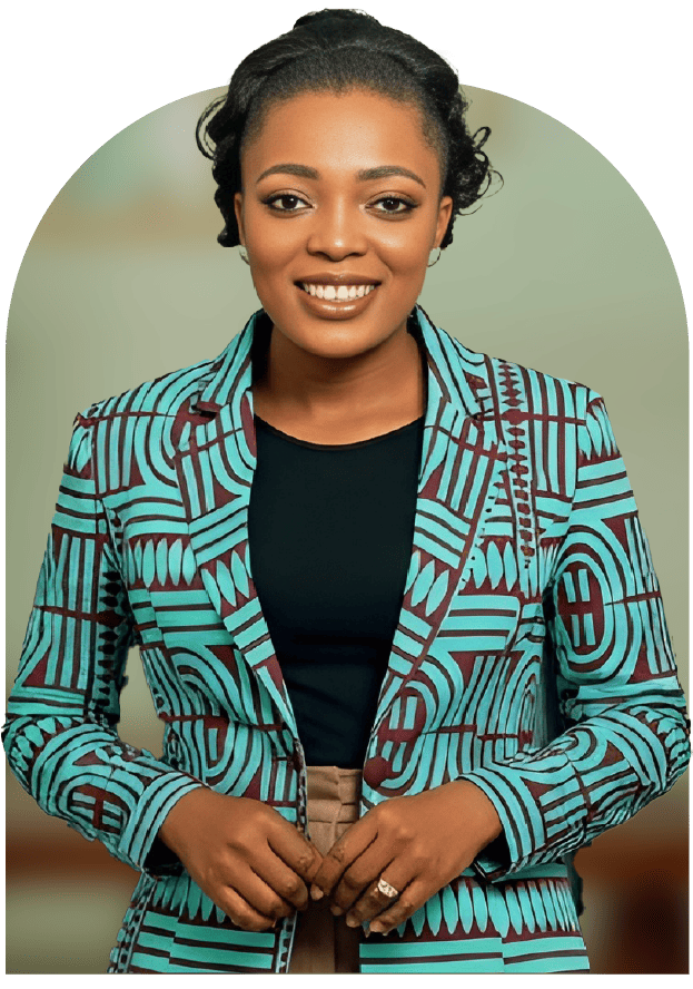 A woman with dark hair styled in twists, wearing a colorful patterned blazer with blue and maroon geometric shapes over a black top, standing against a blurred background.