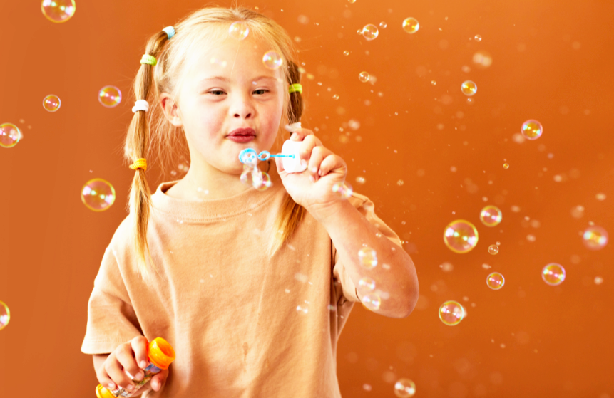 Girl with Down syndrome blowing bubbles