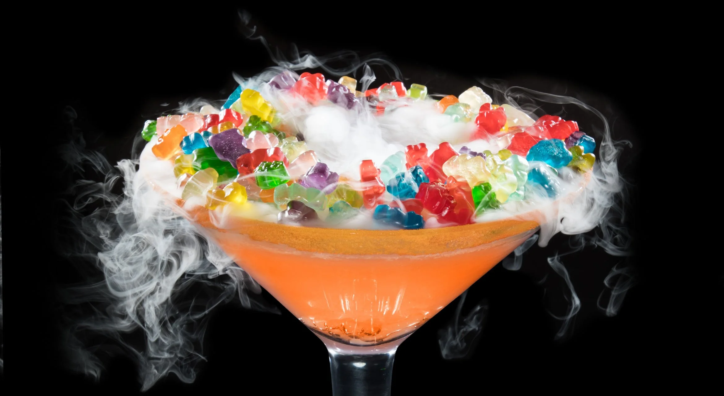 THEE GUMMY BEAR - Deep Eddy Peach Vodka, Sour Apple Pucker Liquor, Watermelon Pucker Liquor, Sweet and Sour Mix , Sprite - Topped with gummy bears. - Rimmed with orange Pucker Powder. (Mocktail Option)