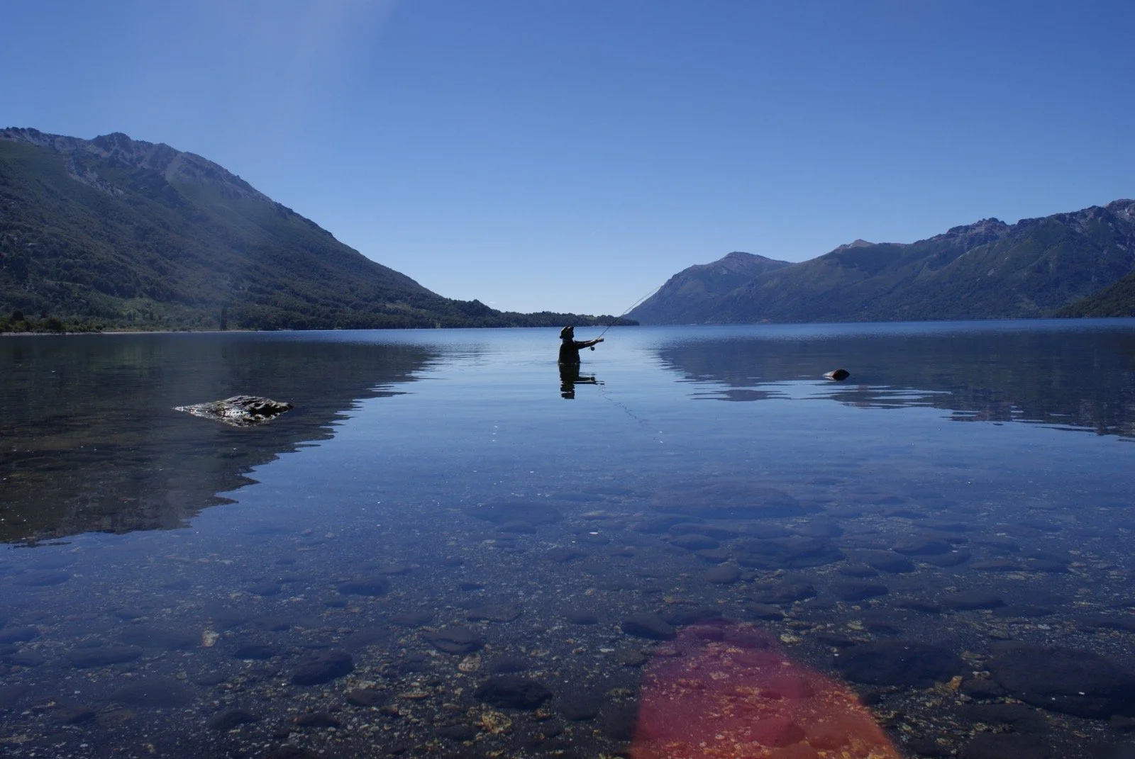 Pesca con mosca tipico de la zona, en un lago rodeado de montañas y vistas extarordinarias.