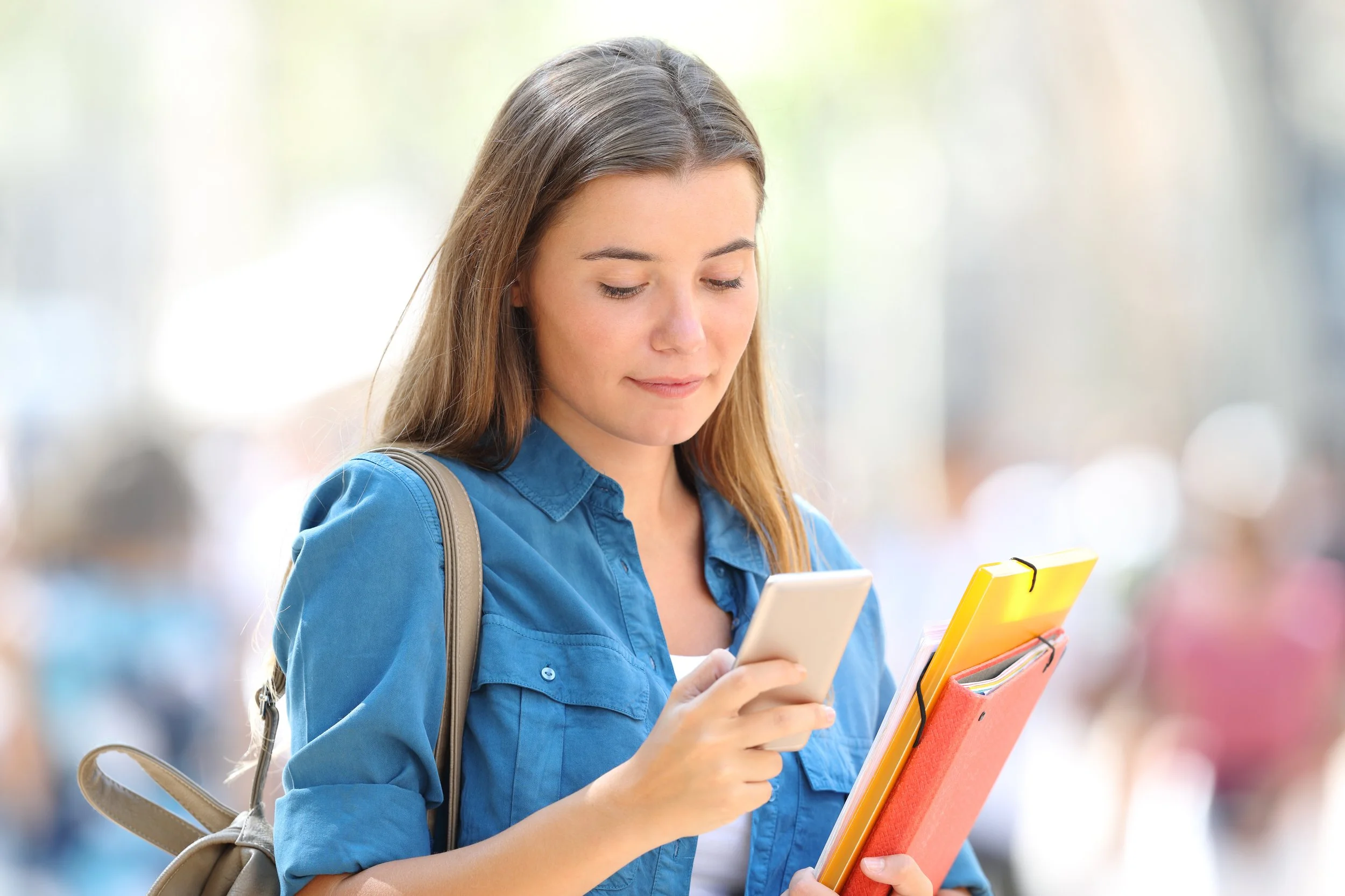 A person in a white long-sleeve shirt using a smartphone.