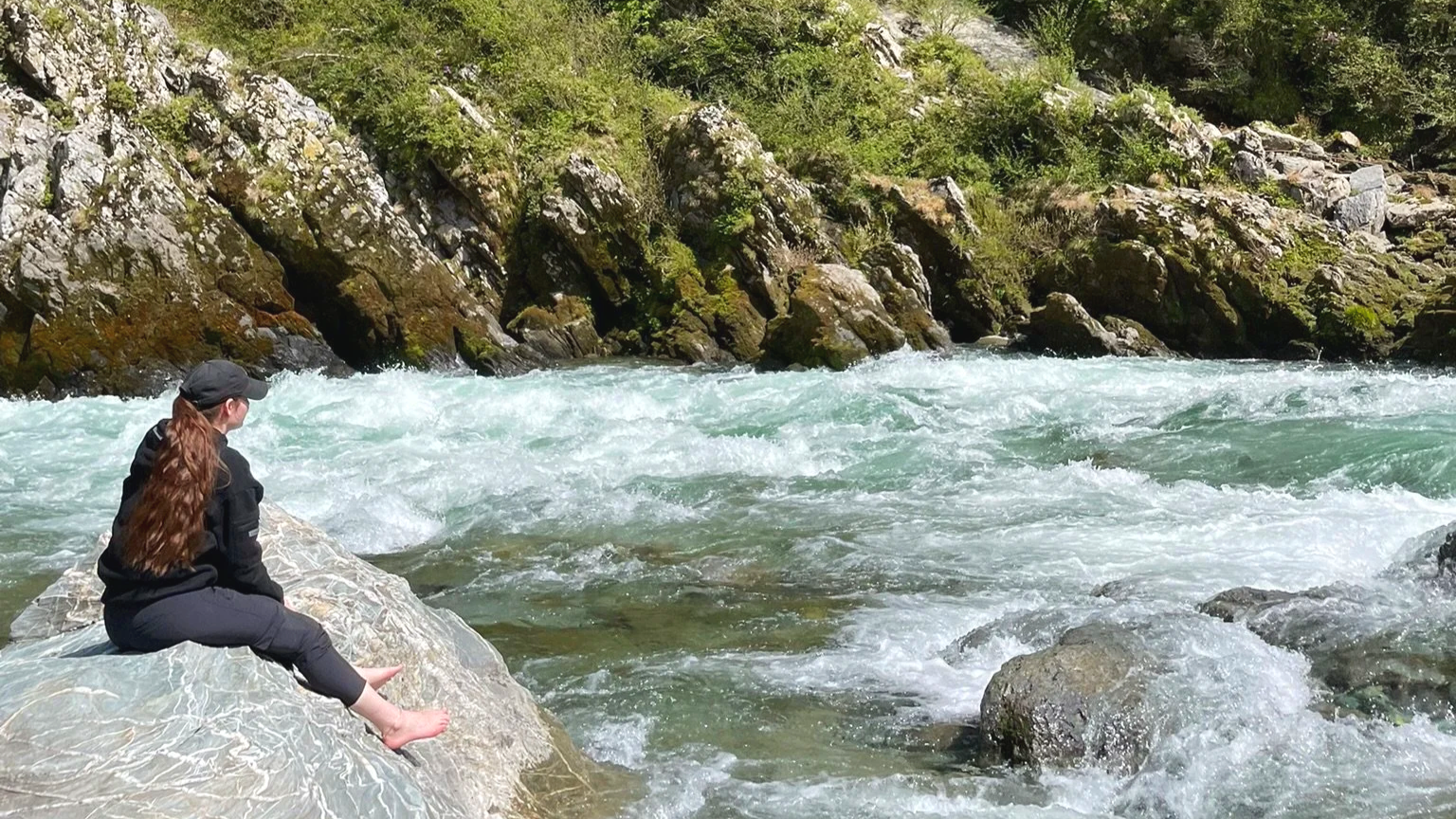 Sophie Conklin sitting by a river.