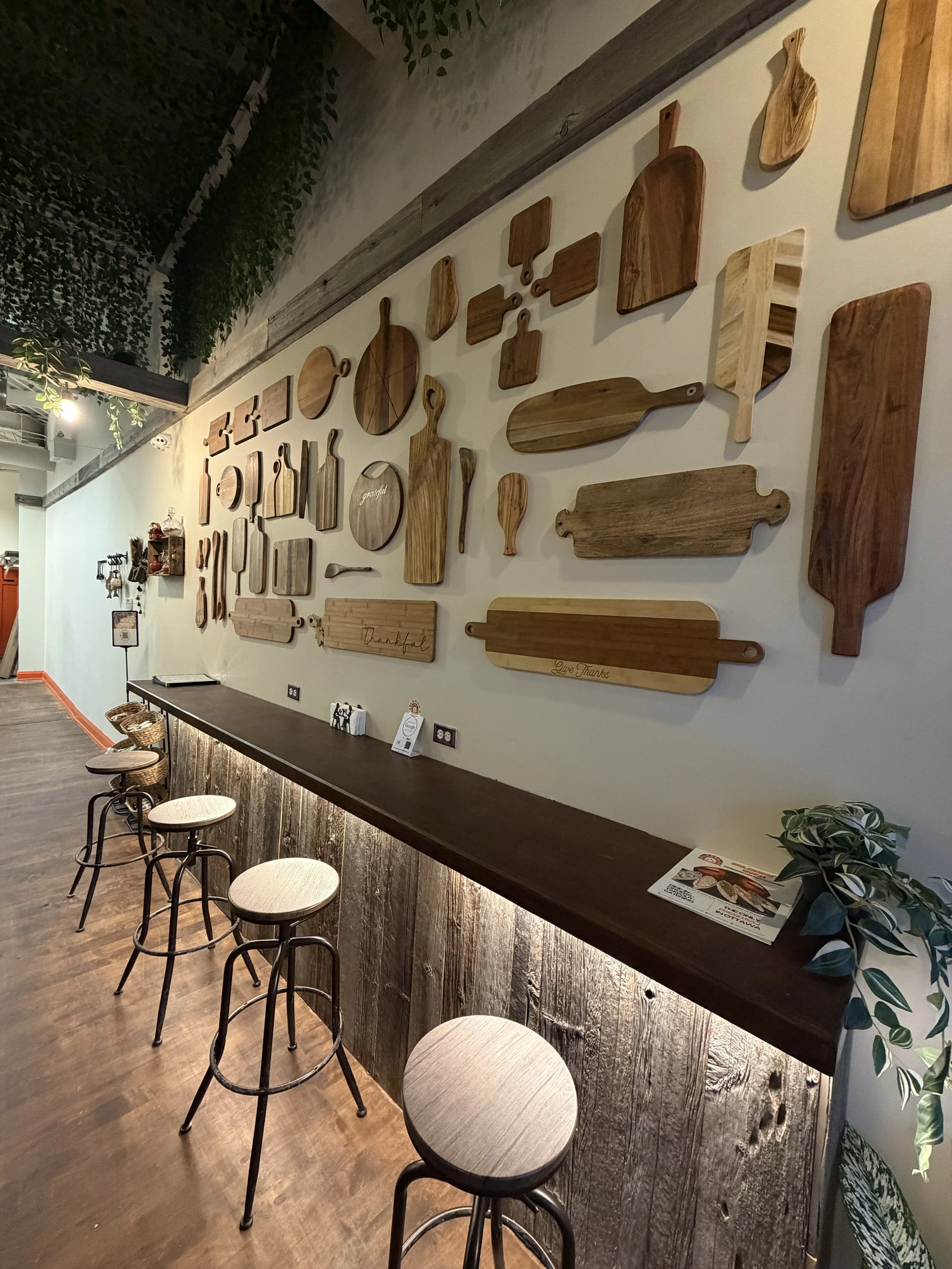 Rustic wooden cutting board feature wall with bar seating inside Solomon’s Oven, a modern halal Middle Eastern bakery and restaurant in Ottawa.