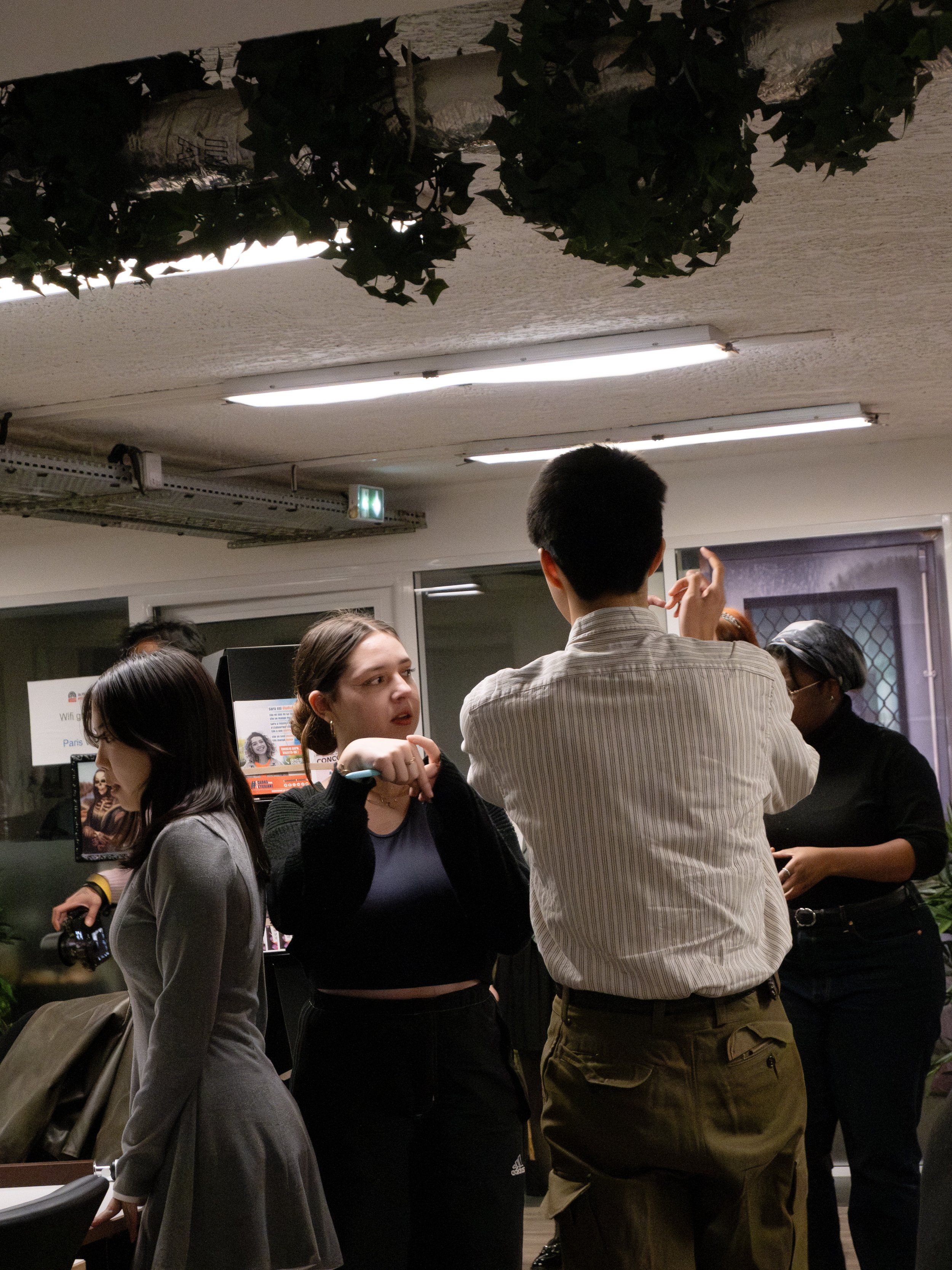Groupe de jeunes adultes discutant dans un espace intérieur.