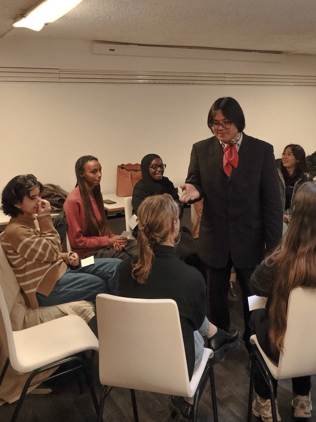 Groupe de personnes en réunion ou conférence, conversation, salle intérieure.