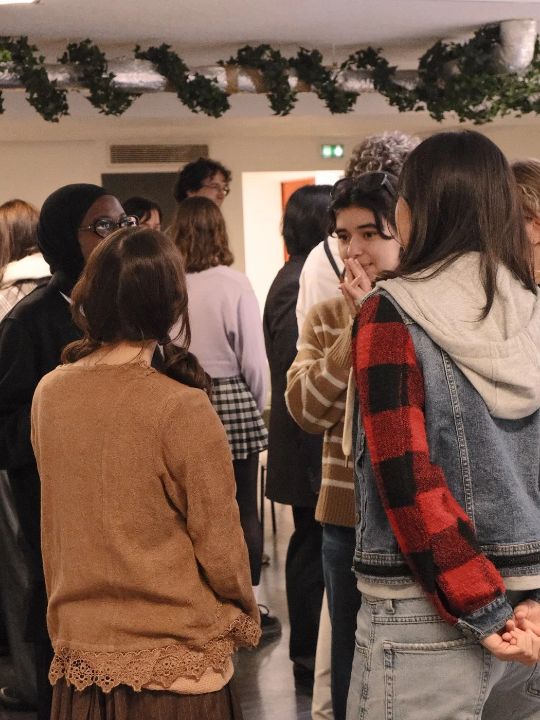 Groupe de personnes discutant lors d'un événement intérieur décoré. 