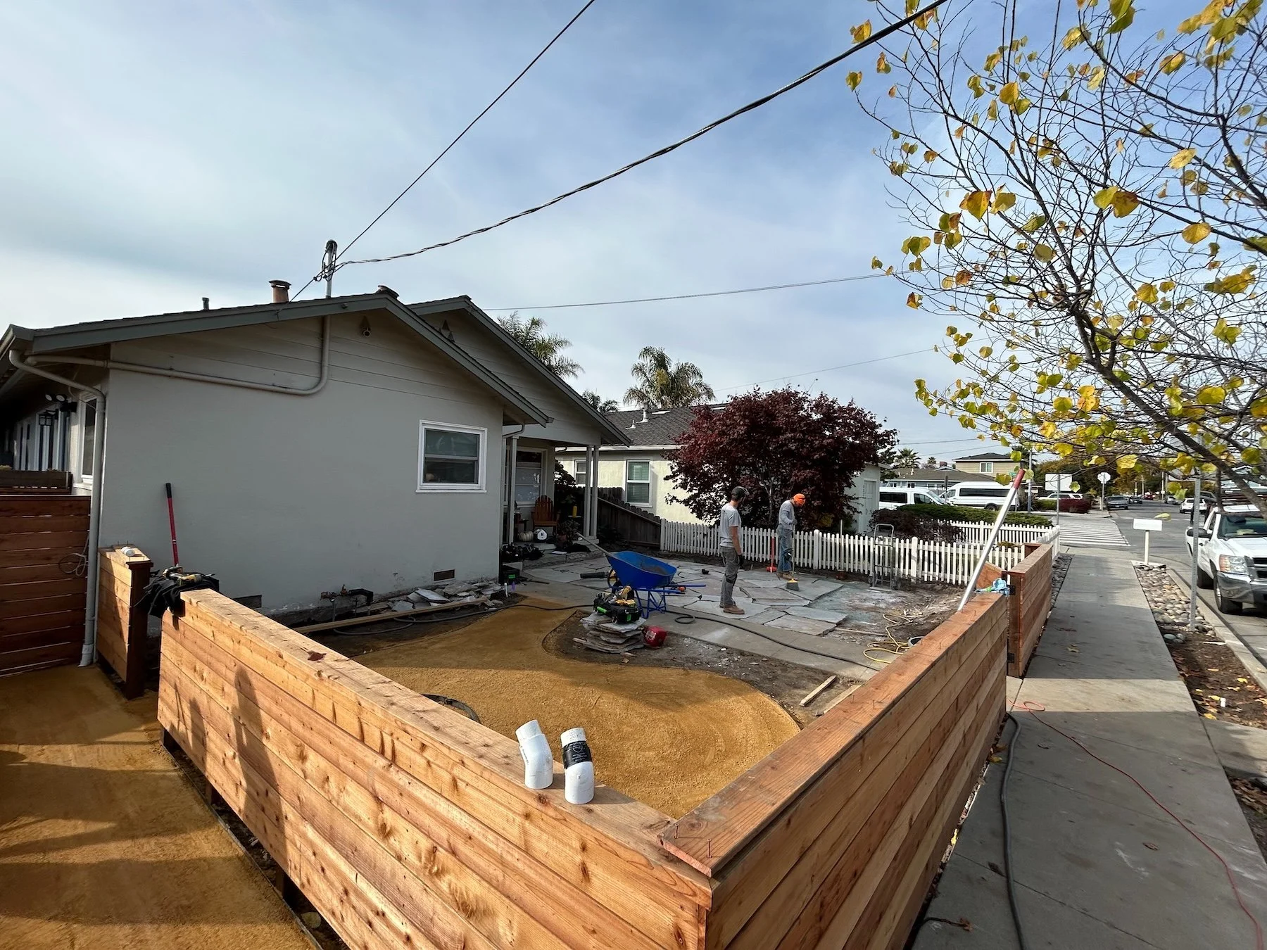 Backyard renovation in progress with new cedar fencing and gravel base being installed