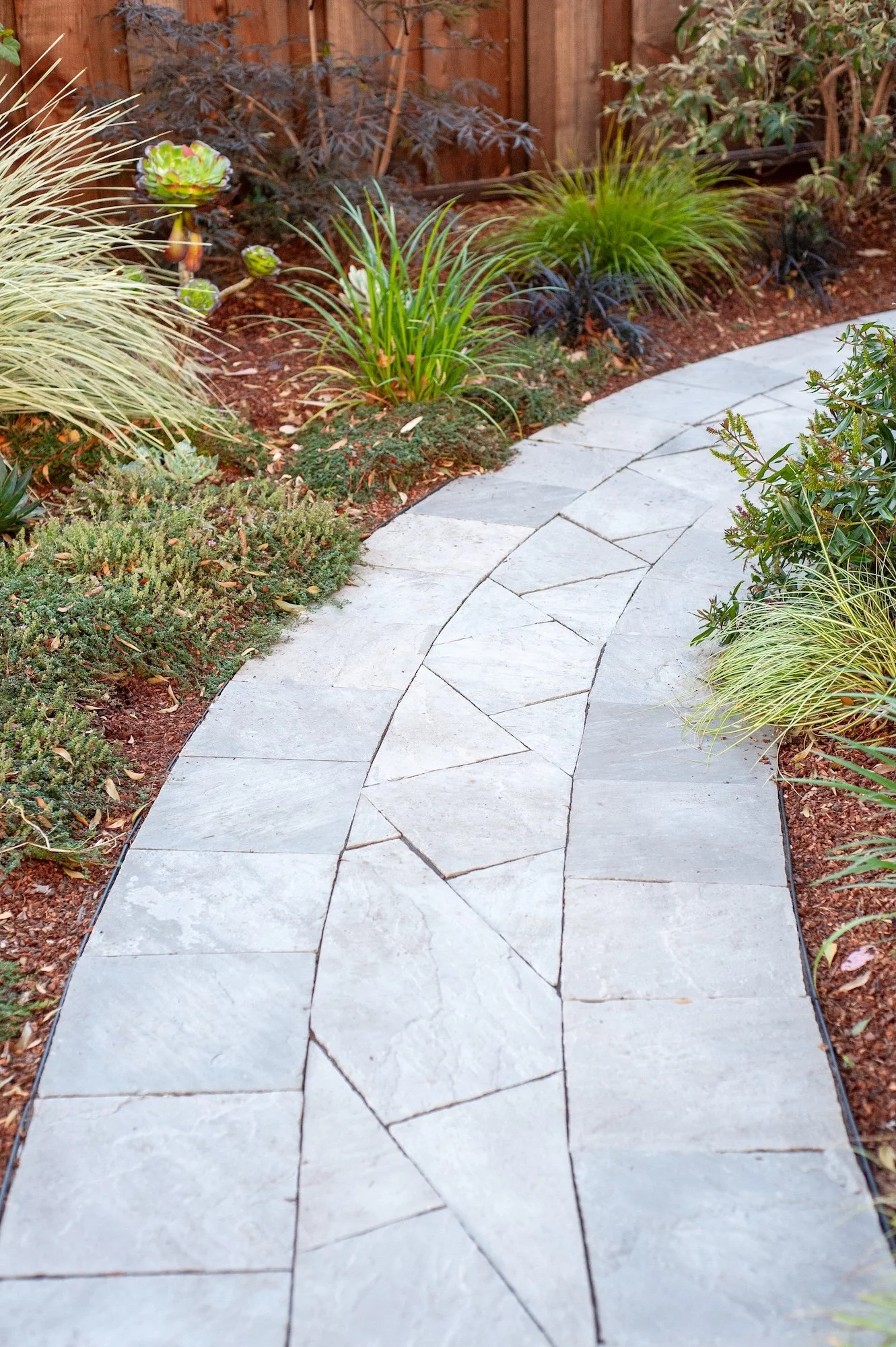 Gorgeous light gray paver walkway flanked by mulching bed and plantings -- Orchard Keepers