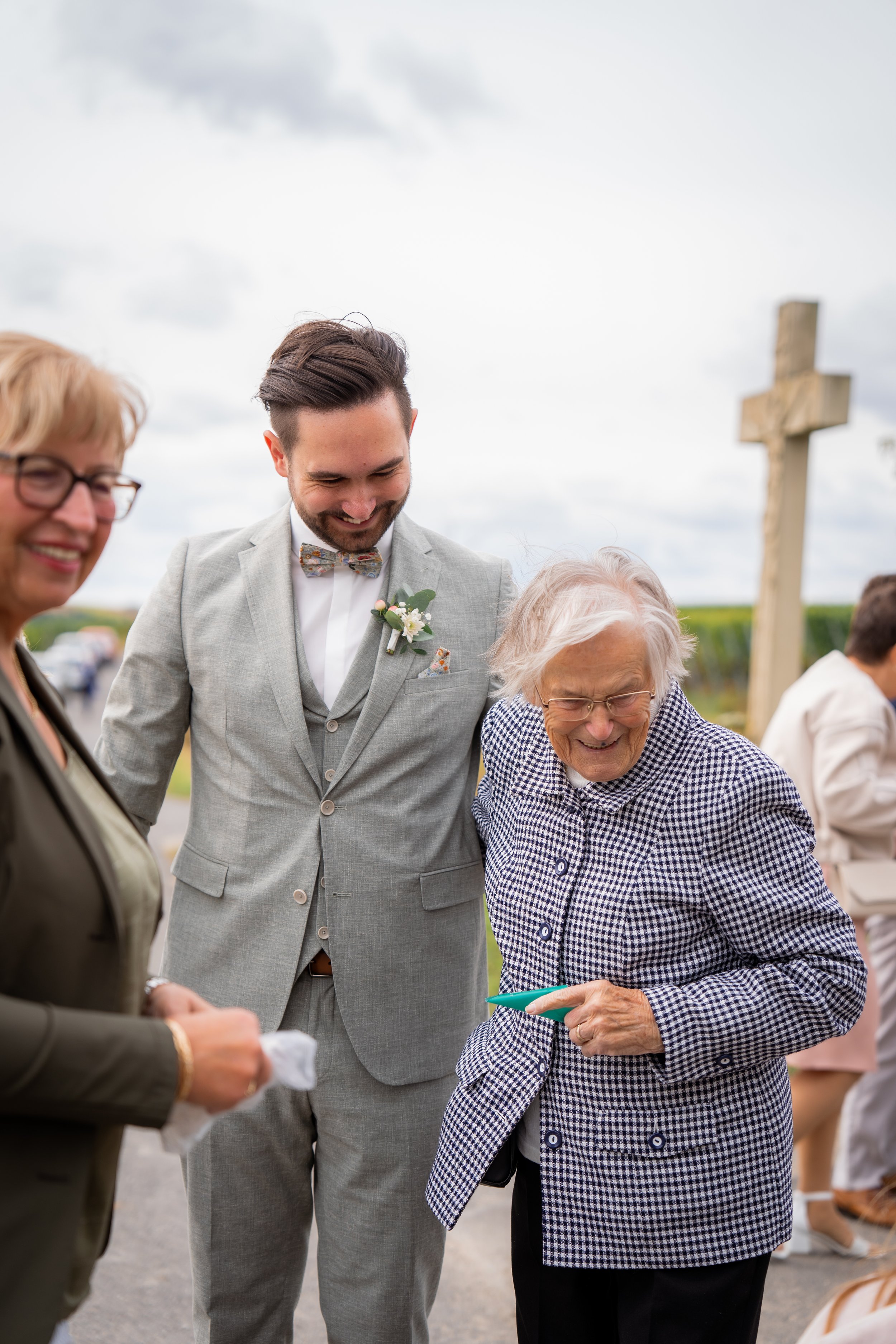 Menschen, die bei einer religiösen Zeremonie, wahrscheinlich einer Hochzeit, an einem Kreuz im Freien stehen und beten.