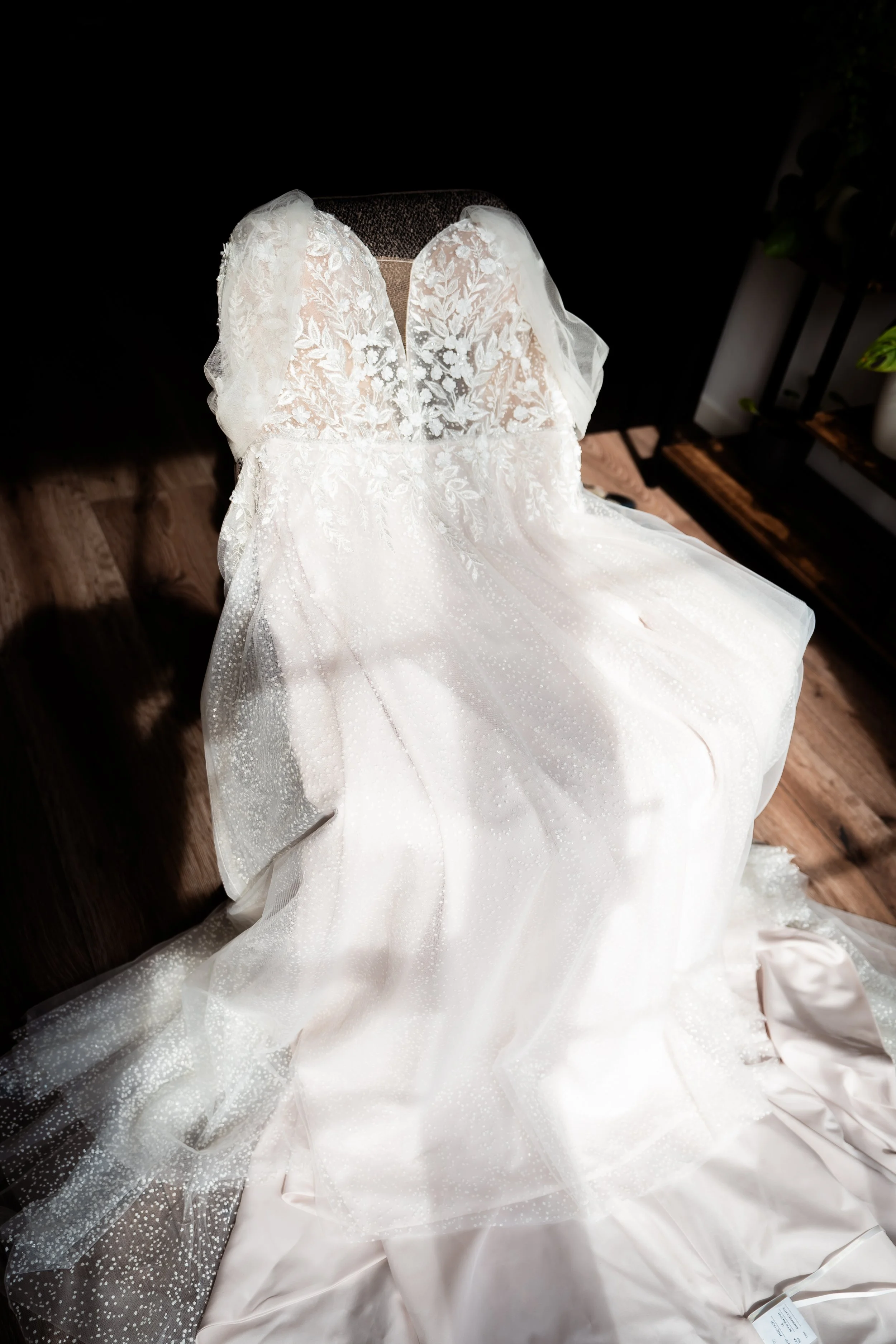 Verfügbare Brautkleid aus Spitze mit floralem Muster, off-shoulder-Design, in einem Geschäfte, auf einem Sitzdisplay