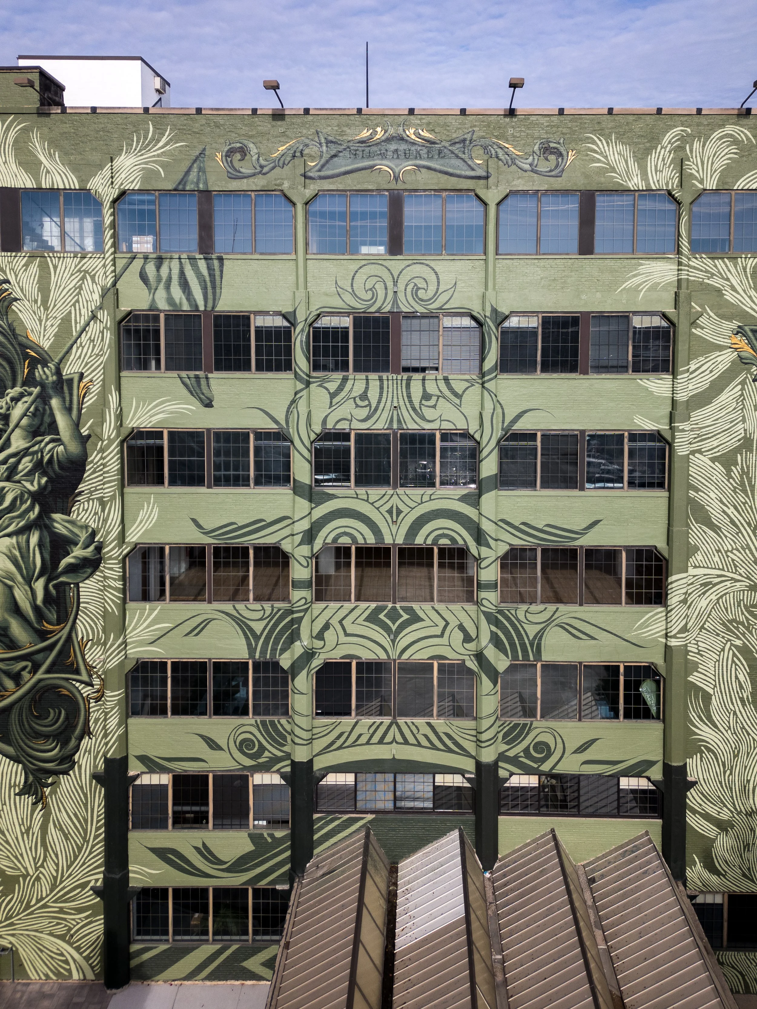 Central facade patterning above the entry canopy—pedestrian-scale branding that elevates curb appeal and leasing tours.