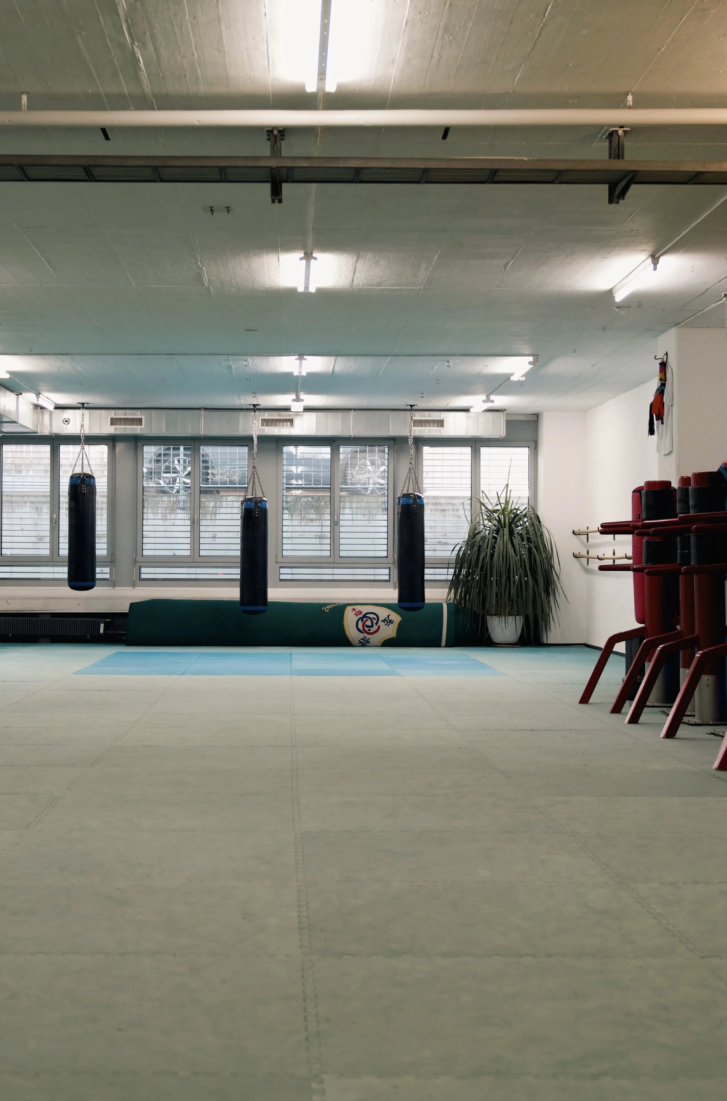 Leeres Kampfsporttrainingraum mit Boxing Bags, Trainingsmatten und Trainingszubehör.