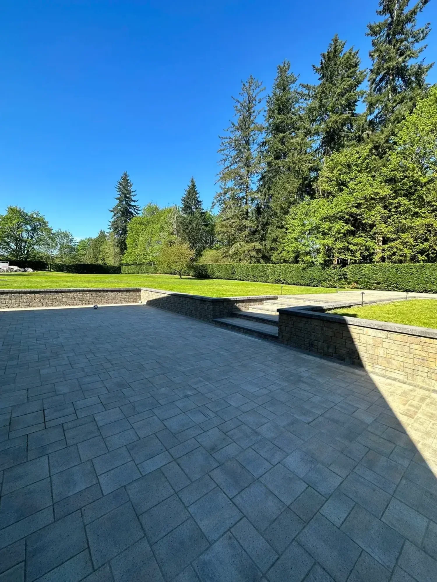 Custom patio and retaining wall landscaping in Edmonds WA with tiered yard and paved outdoor space