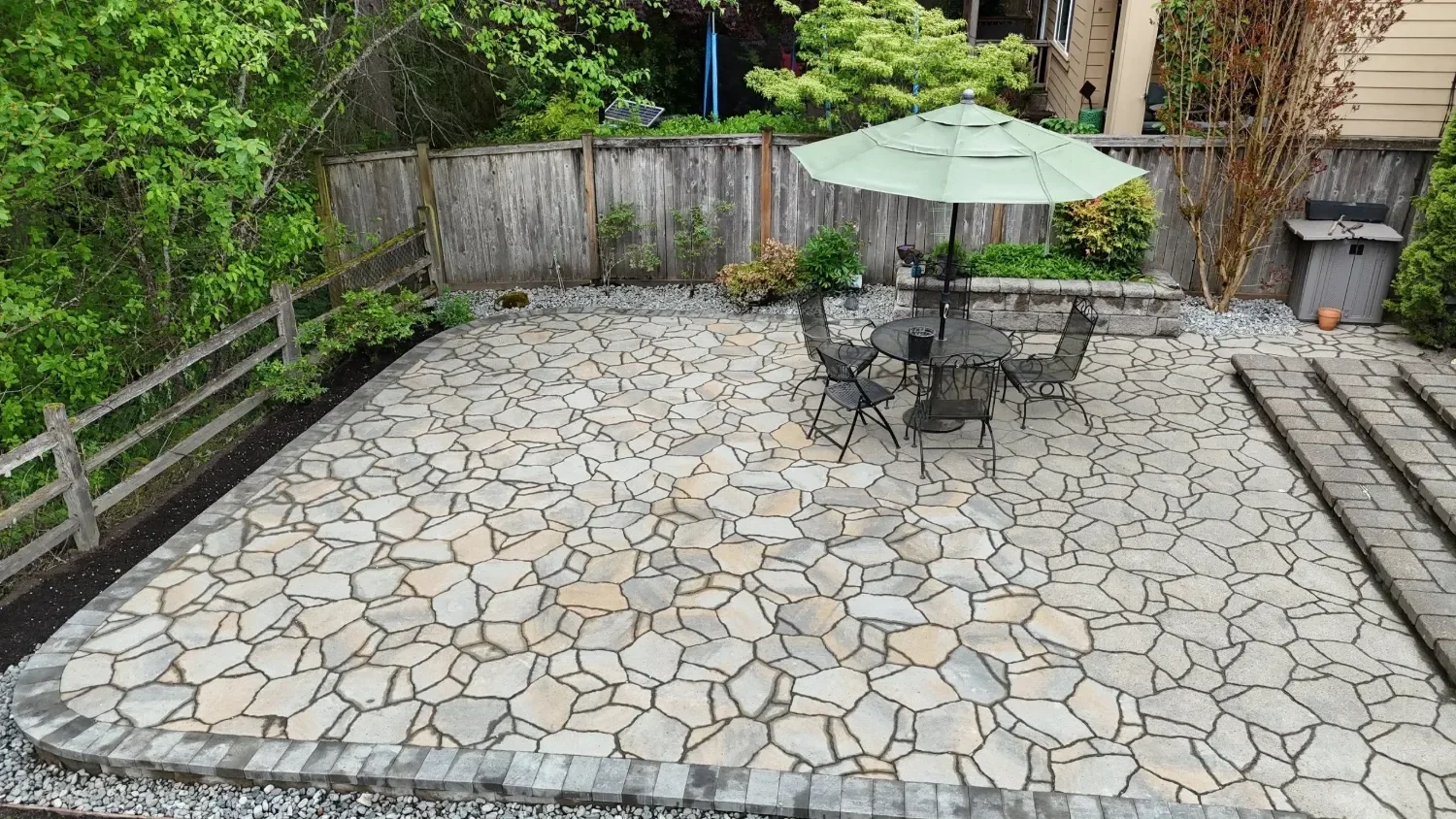 Custom natural stone patio installation at a Seattle, WA residential backyard with outdoor seating