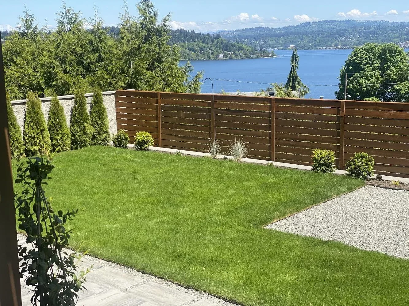 Backyard lawn and modern deck by landscape designer in Sammamish, WA